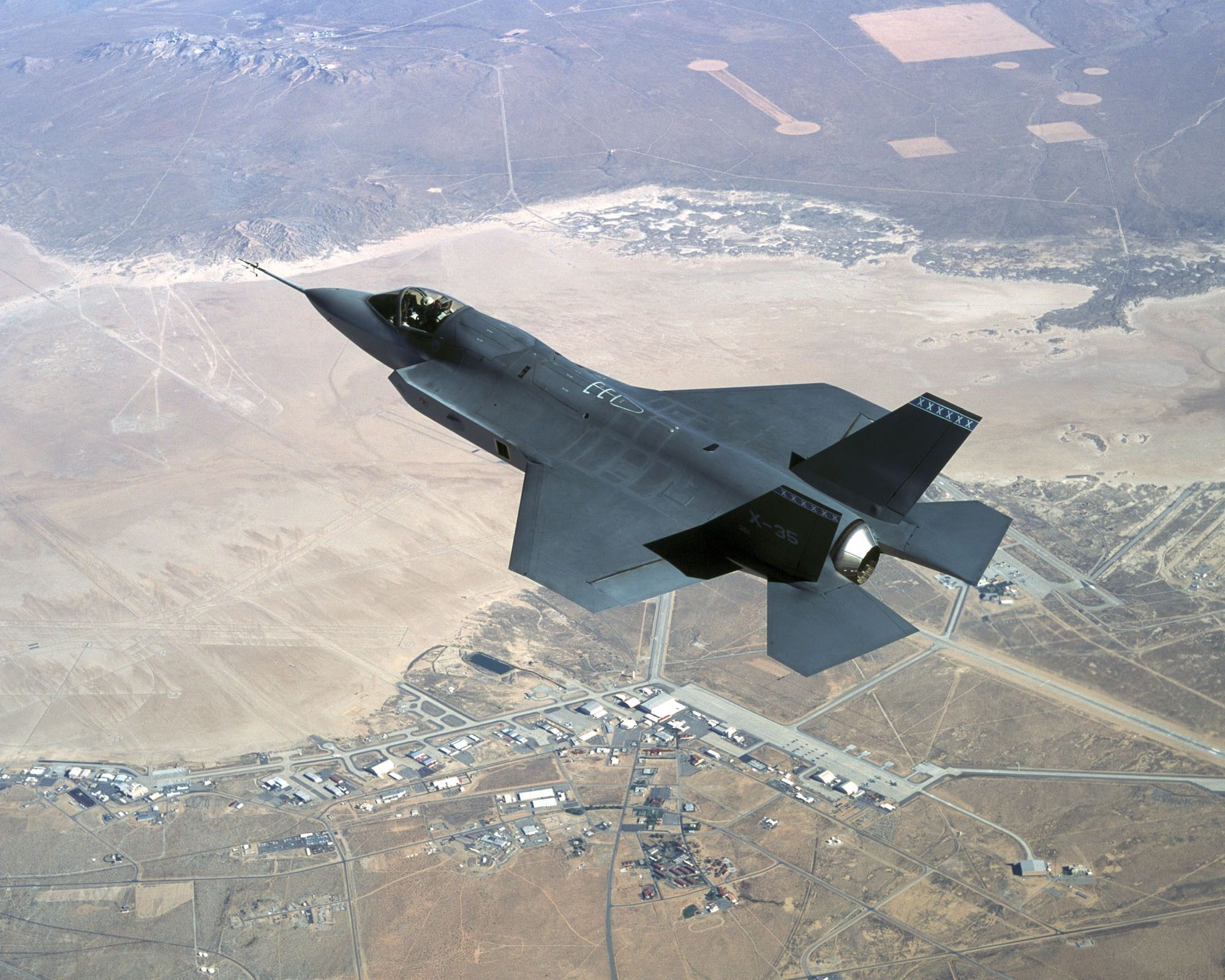 F-35 fighter jet flying over desert landscape HD Wallpaper