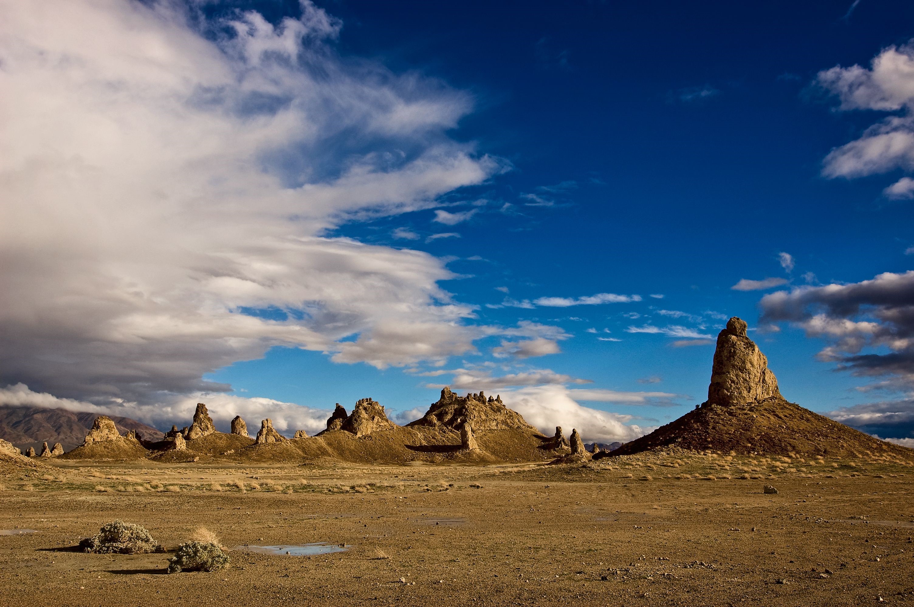 Desert landscape with rock formations and clouds HD Wallpaper