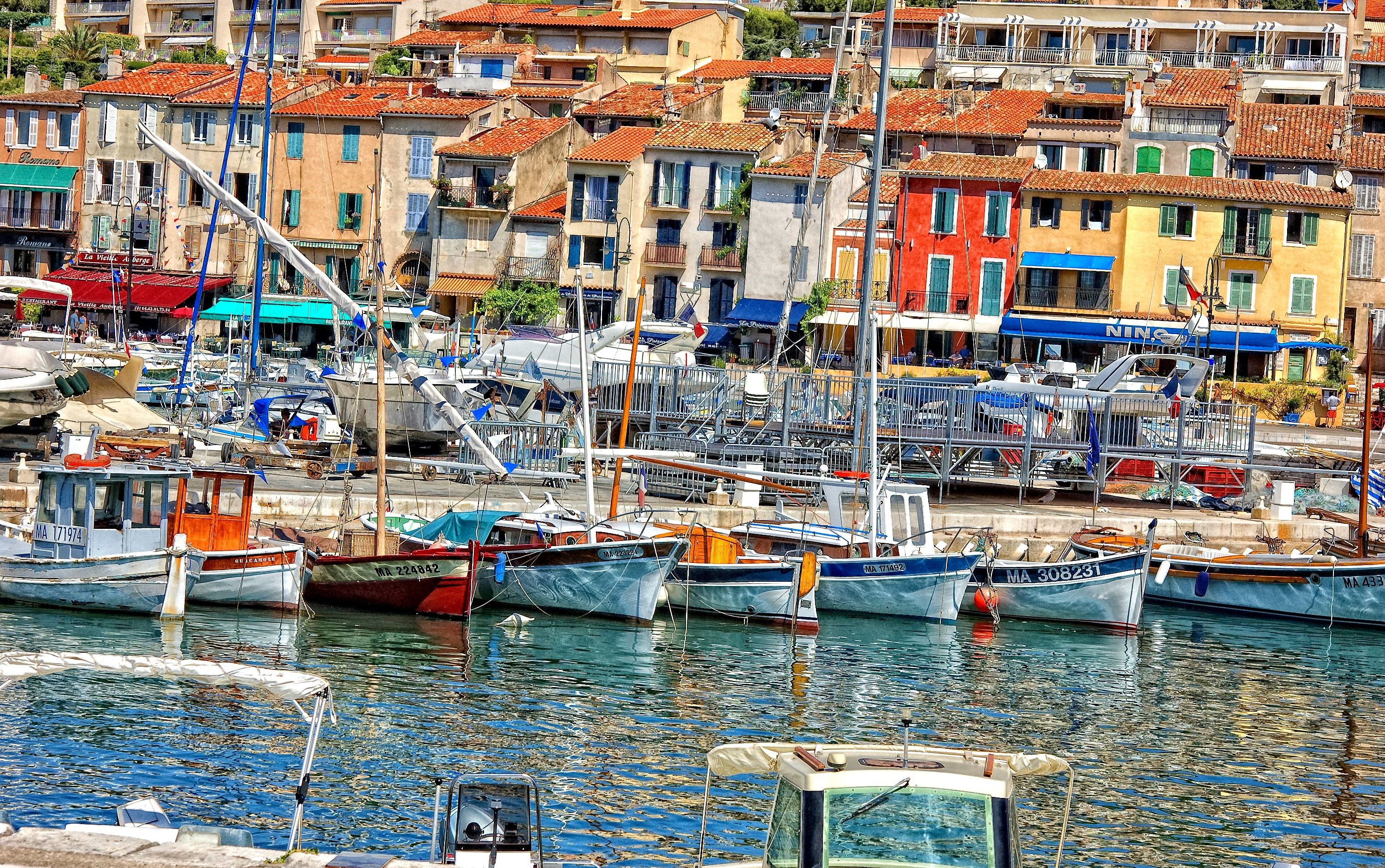 Boats docked in a colorful harbor in France HD Wallpaper