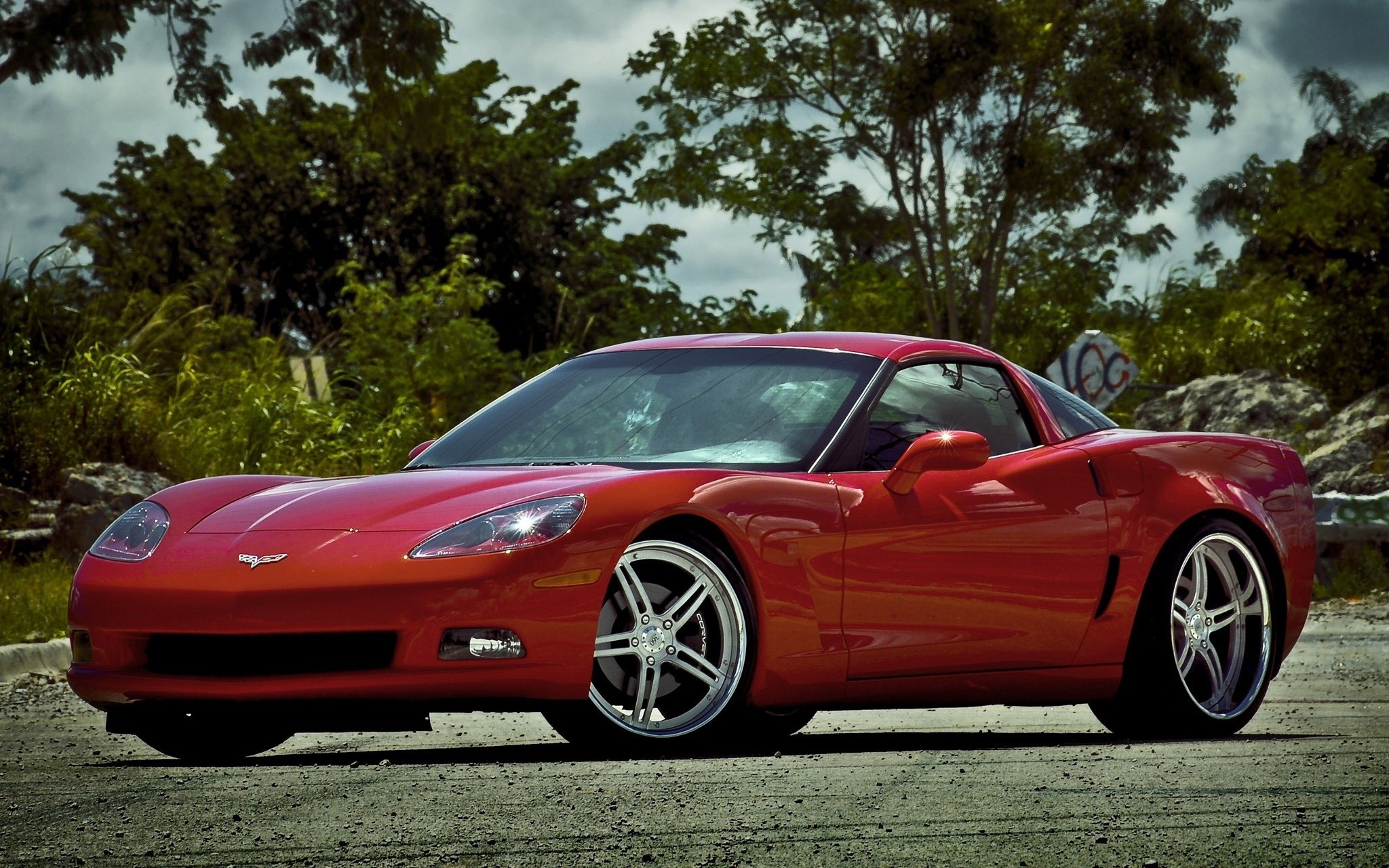 Red Chevrolet Corvette parked on a dirt road HD Wallpaper