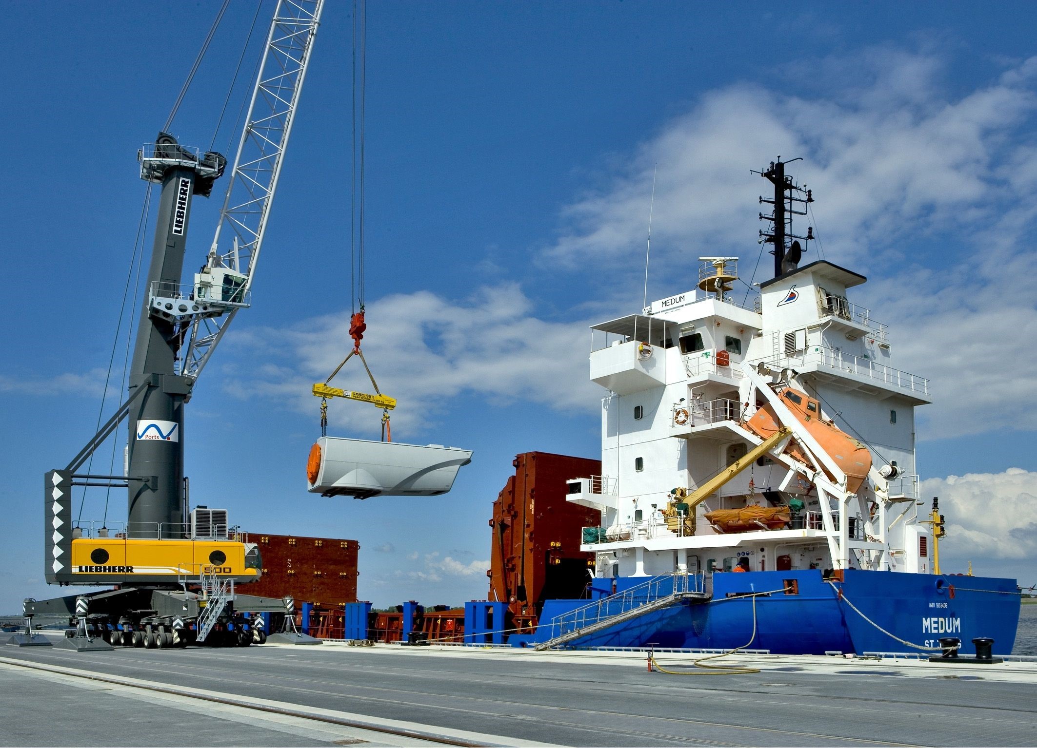 Crane loading wind turbine part onto ship HD Wallpaper