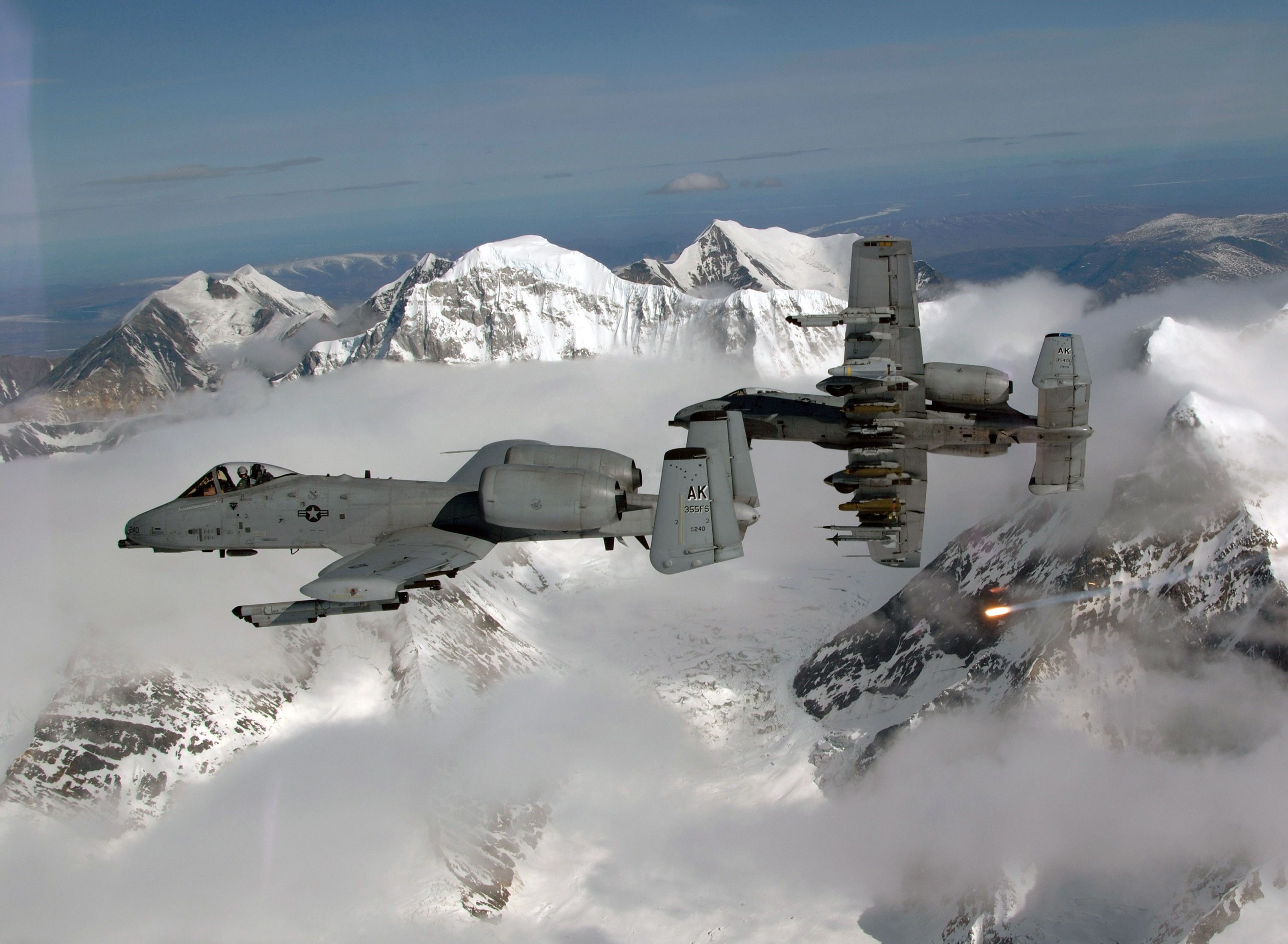 Two A-10 Thunderbolt II aircraft flying over snowy mountains HD Wallpaper