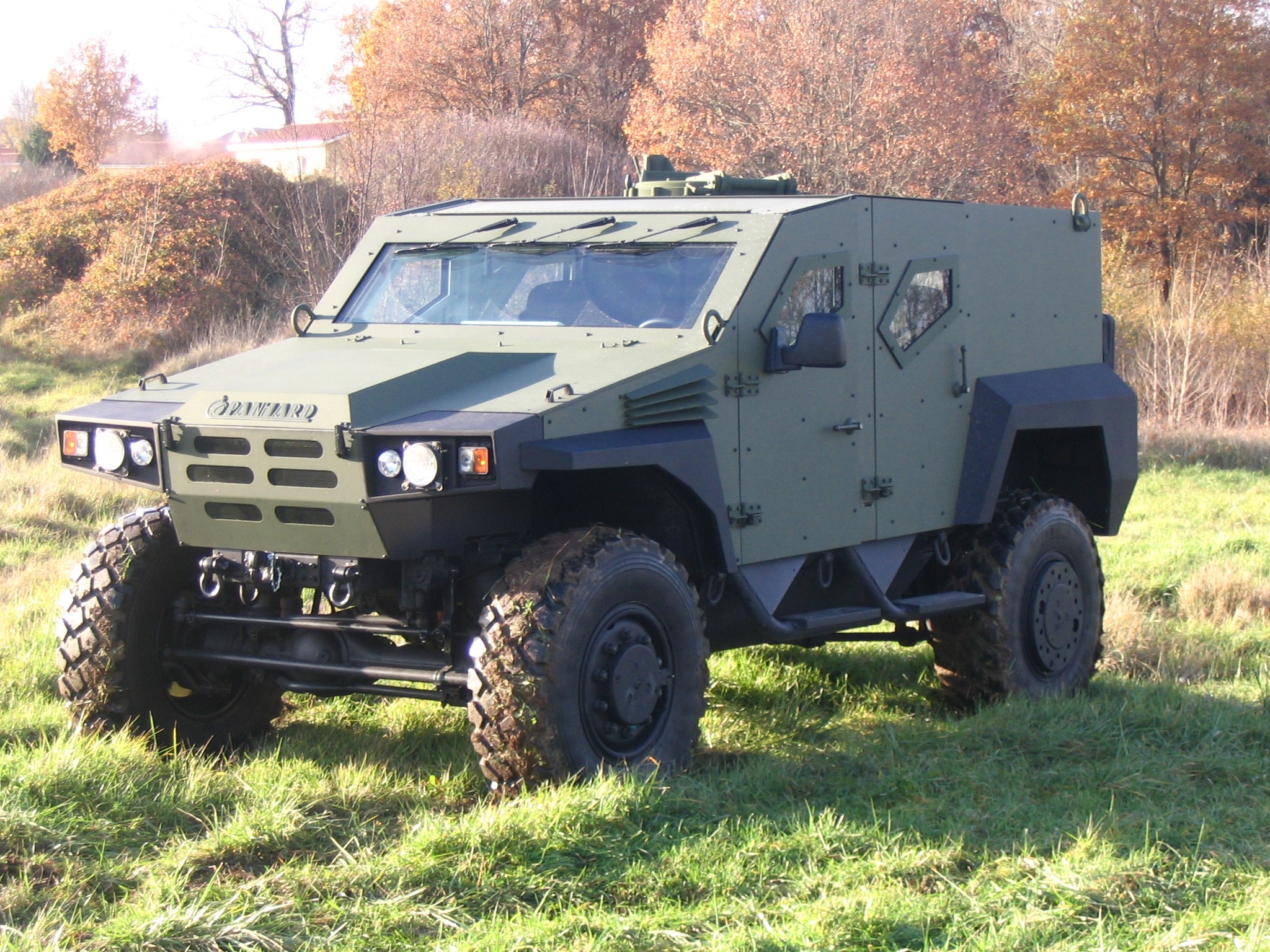 Green armored military vehicle in a field HD Wallpaper