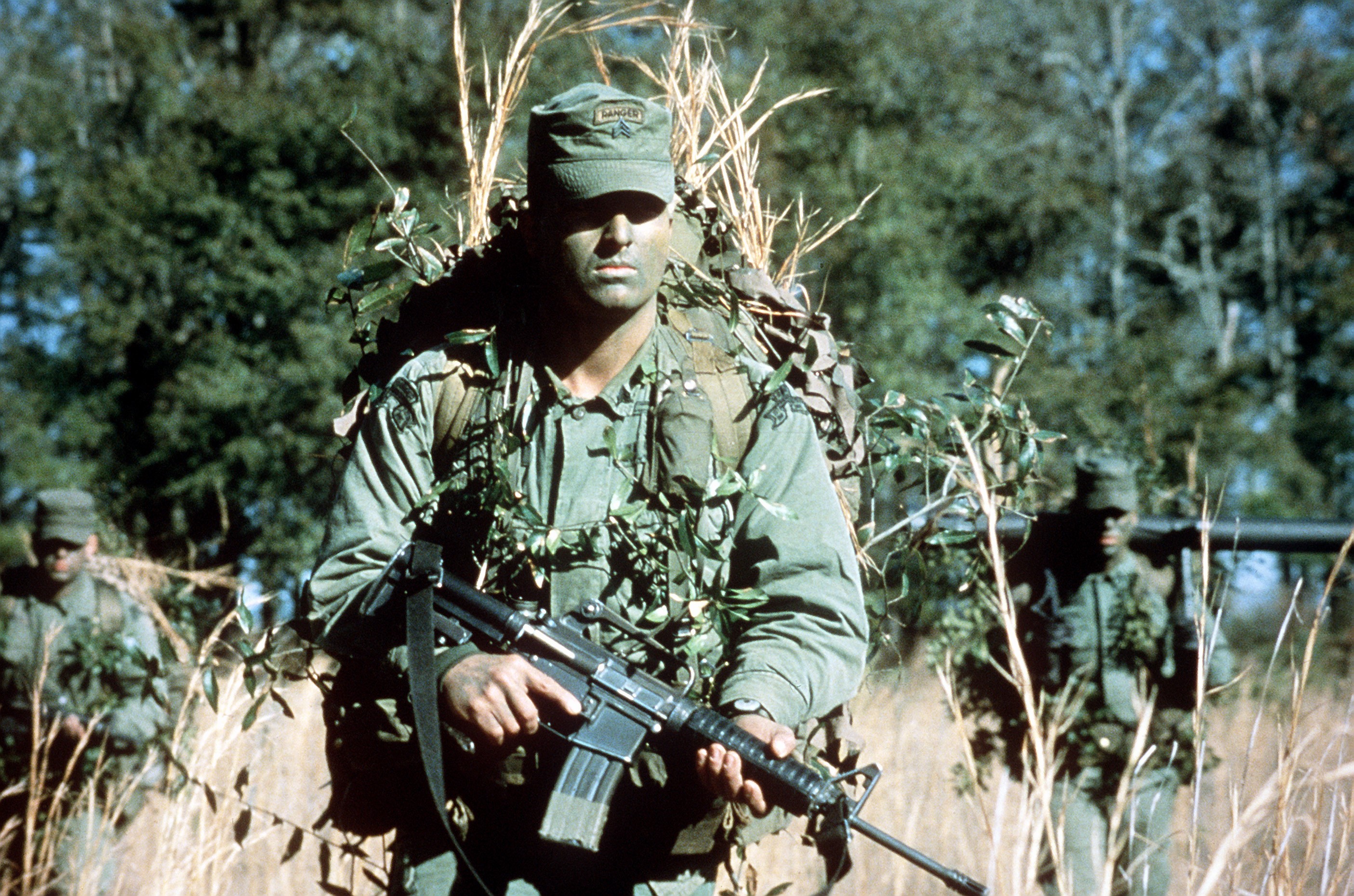 Soldiers in camouflage with rifles in a field HD Wallpaper