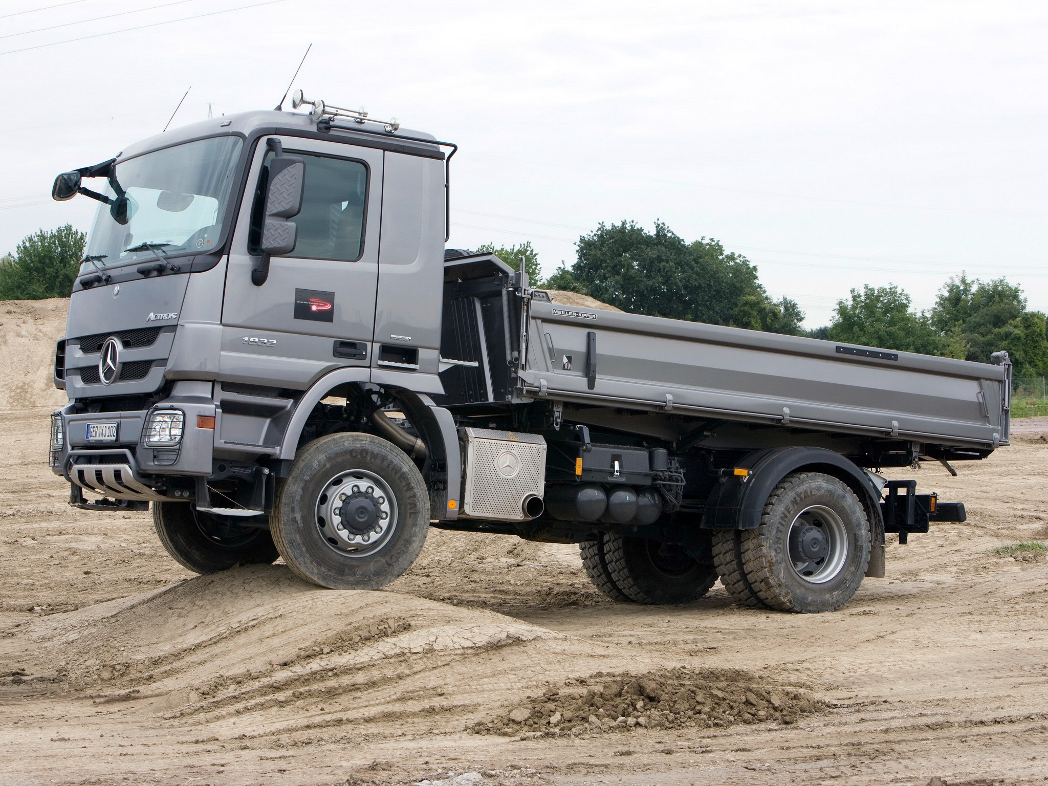Mercedes-Benz dump truck on a dirt mound HD Wallpaper