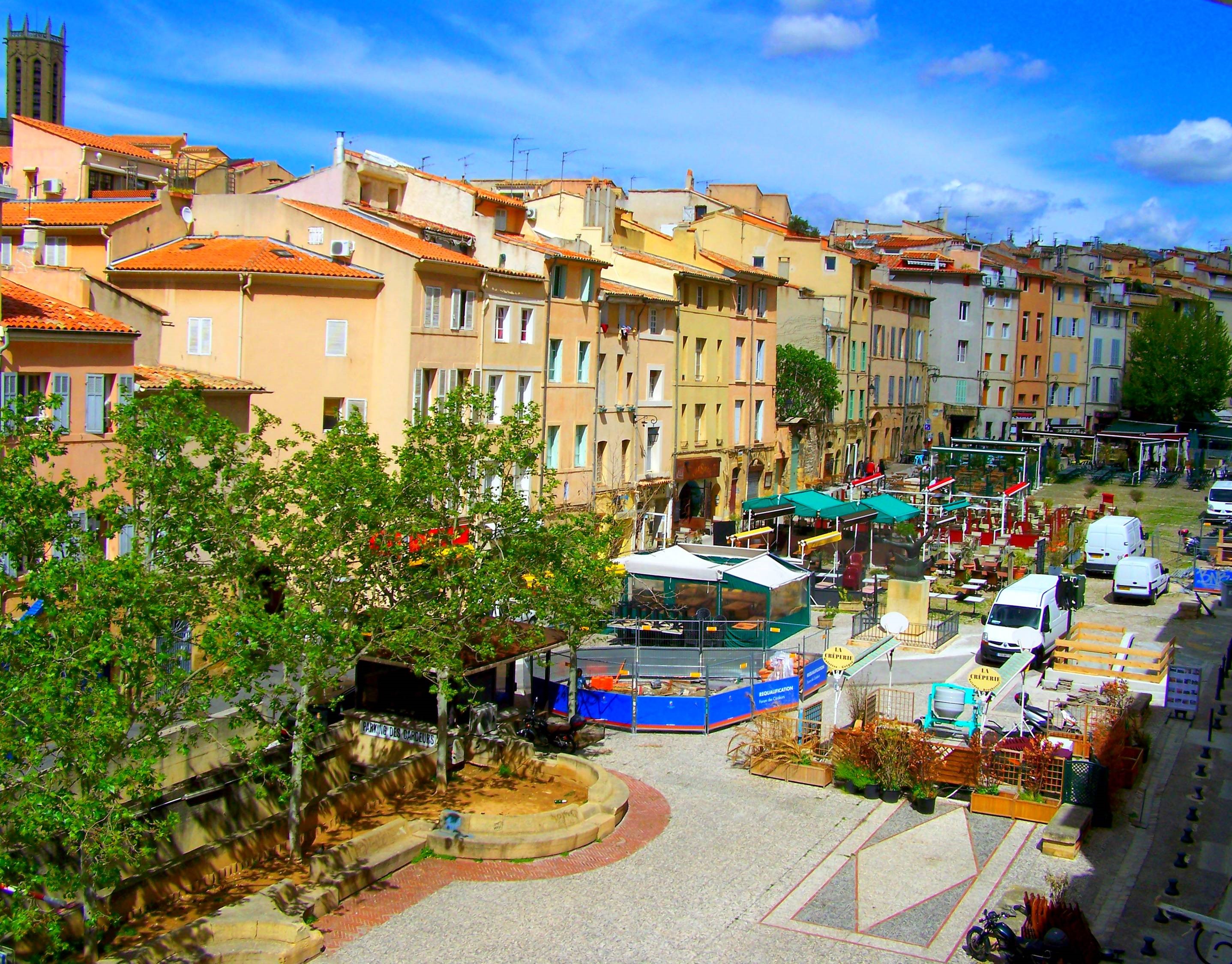 Town square with colorful buildings and market stalls HD Wallpaper