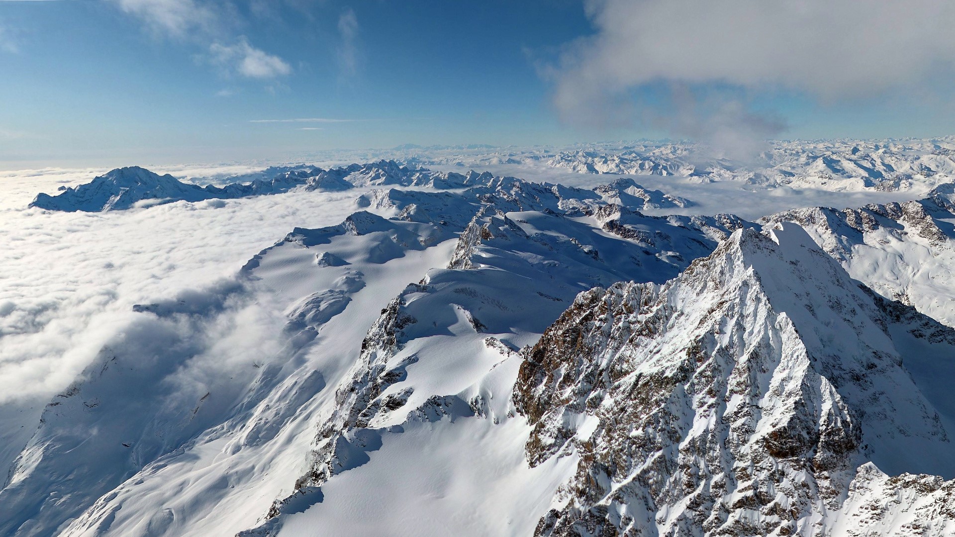 Snowy mountain range above clouds HD Wallpaper