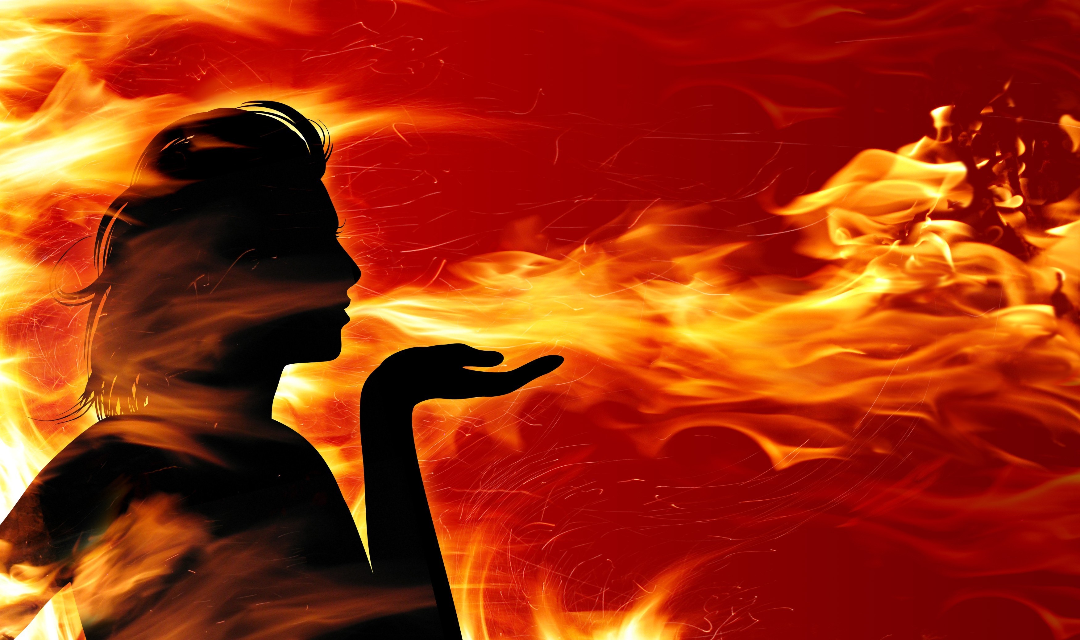 Silhouette of a woman blowing fire HD Wallpaper