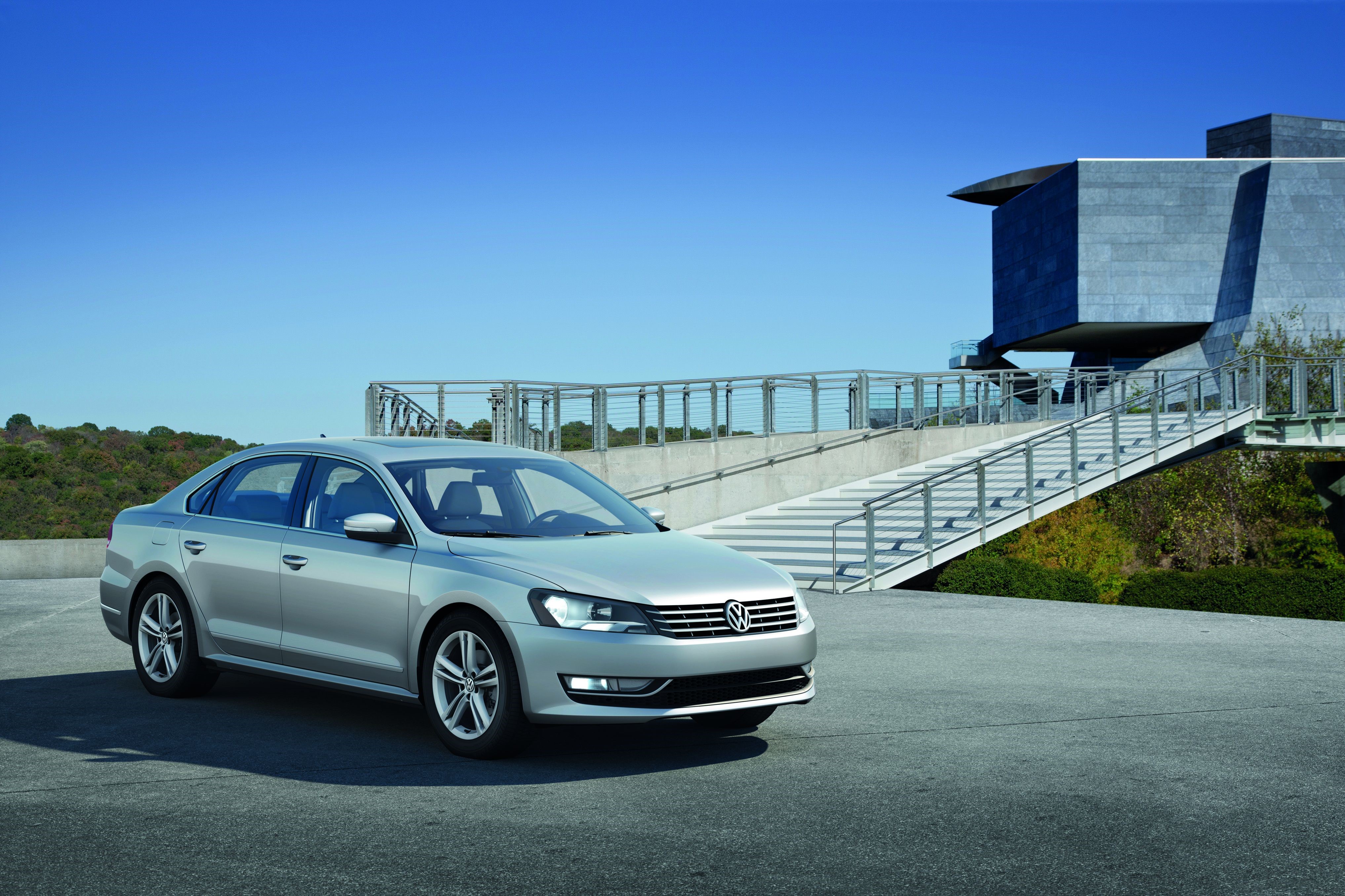 Silver Volkswagen sedan parked near a modern building HD Wallpaper