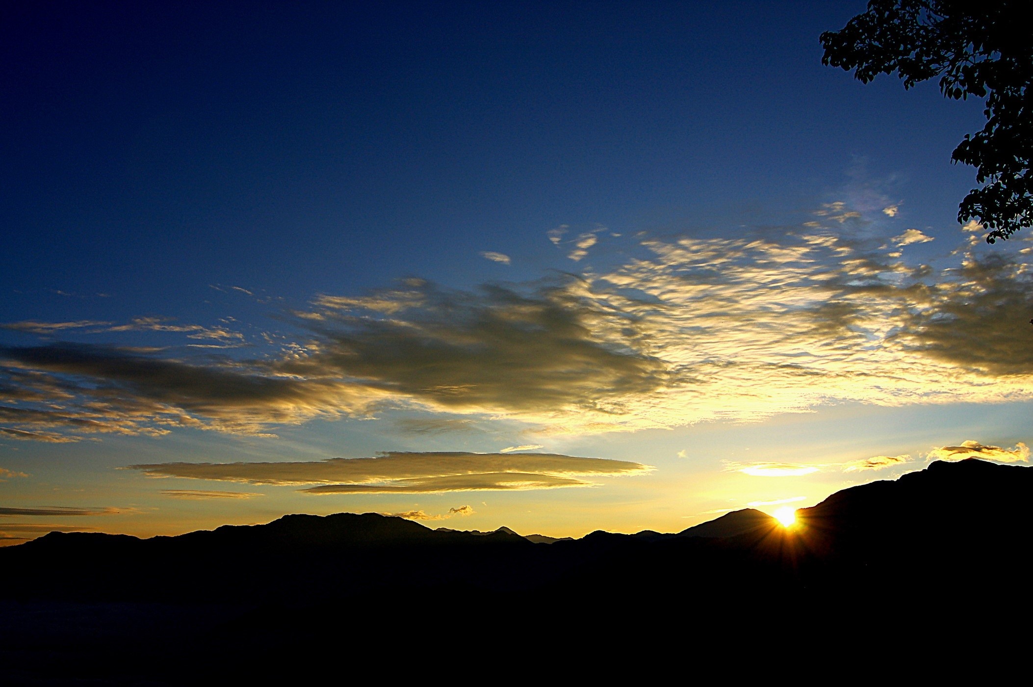 Sunset over mountains with clouds HD Wallpaper