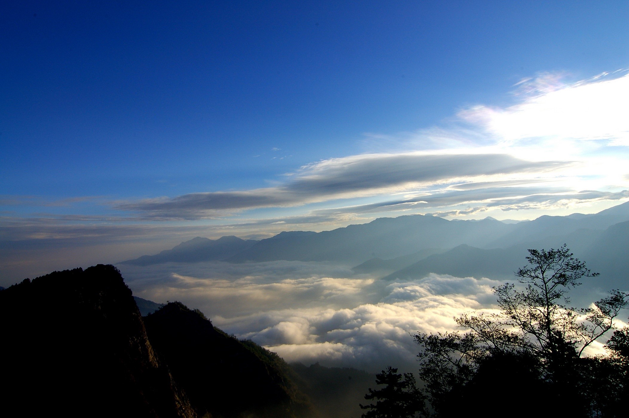 Mountains above a sea of clouds at sunrise HD Wallpaper