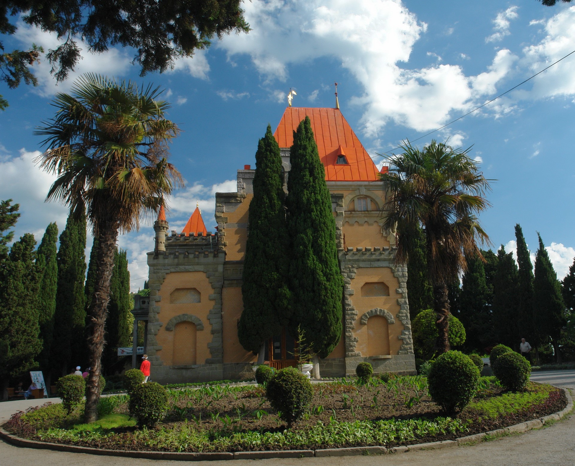 Palace-like building with orange roof and palm trees HD Wallpaper