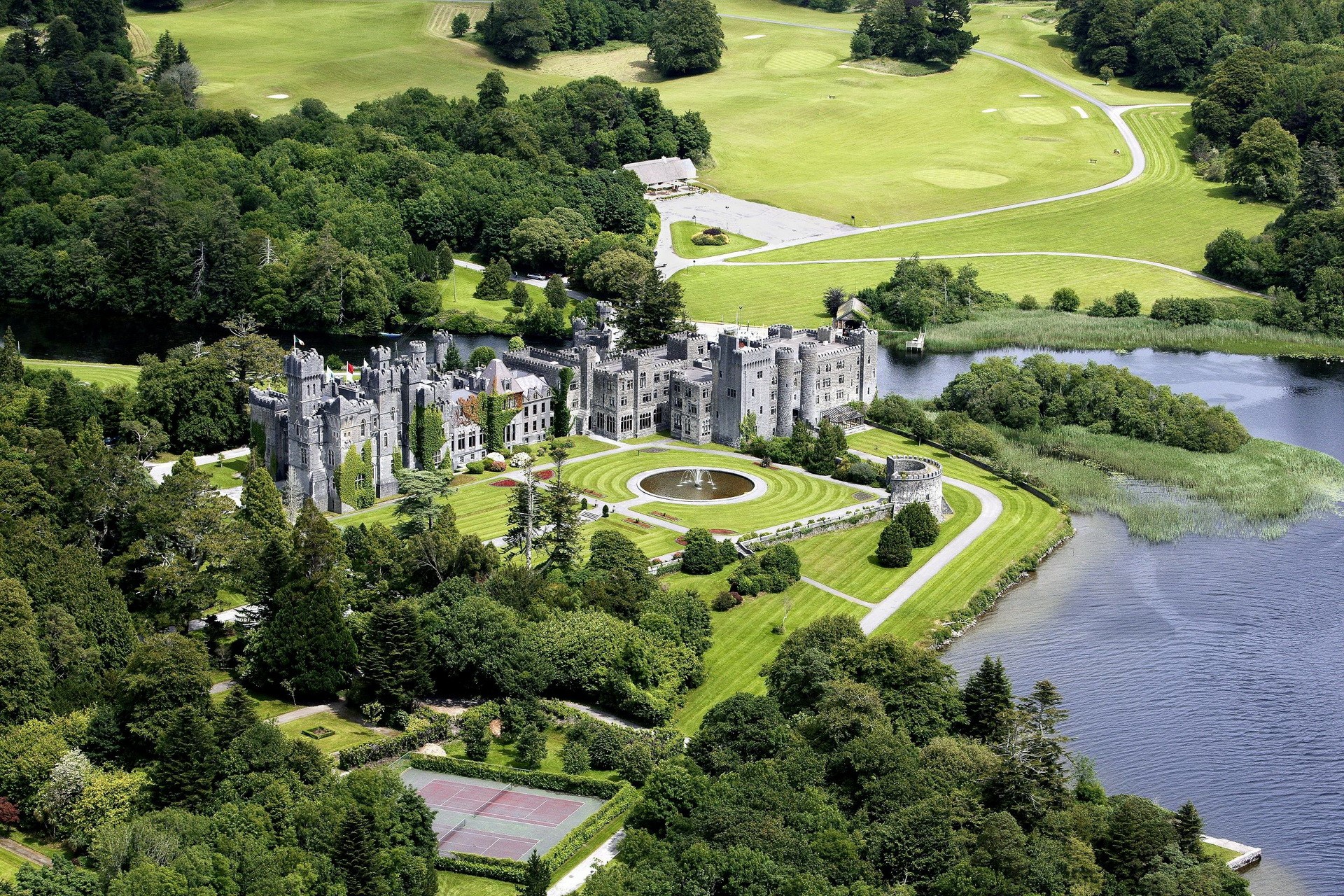 Ashford Castle and its grounds by a lake HD Wallpaper