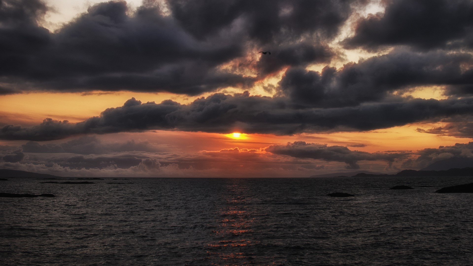 Sunset over the ocean with dark clouds HD Wallpaper