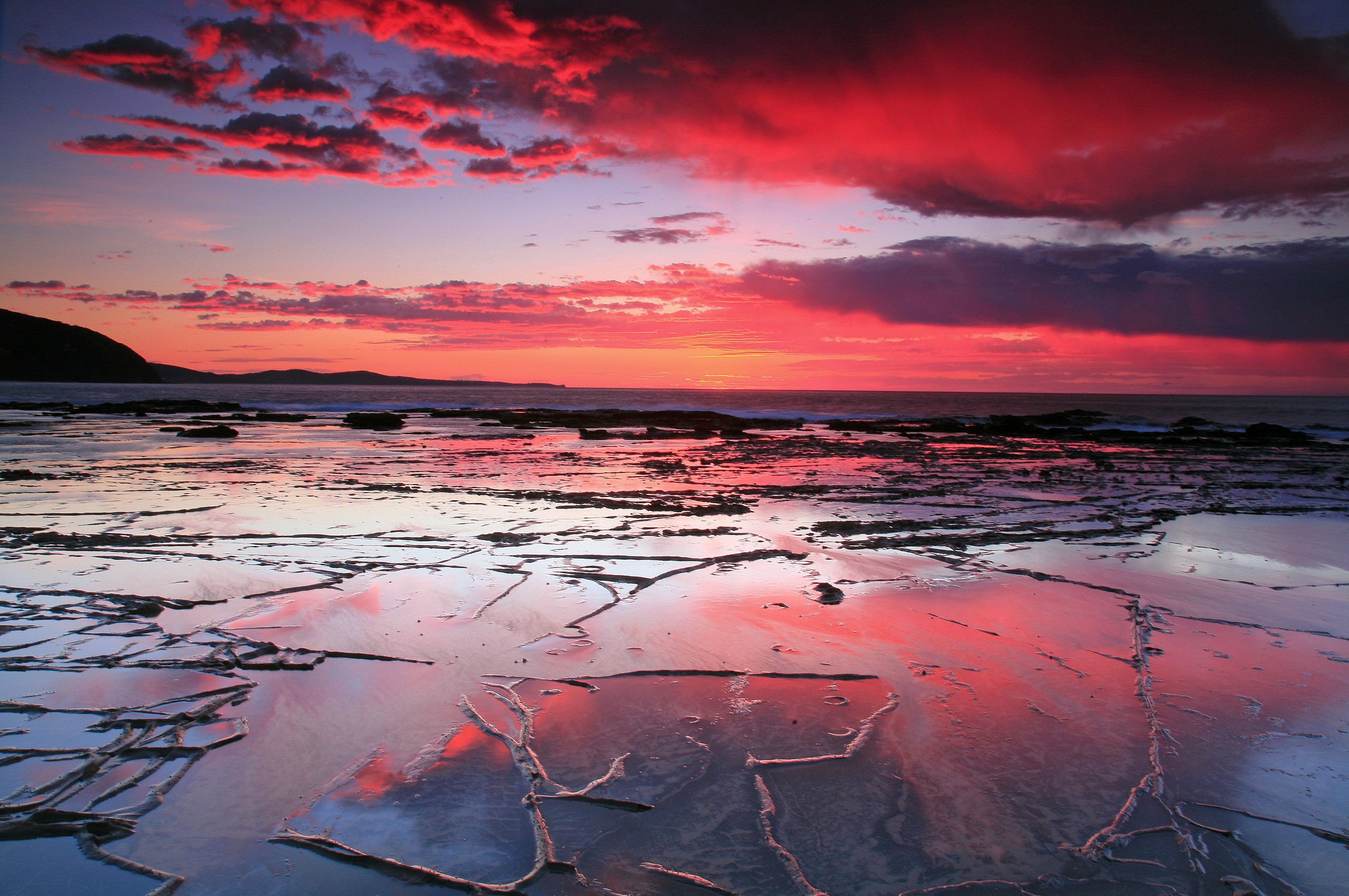 Sunset over rocky coastline with colorful clouds HD Wallpaper