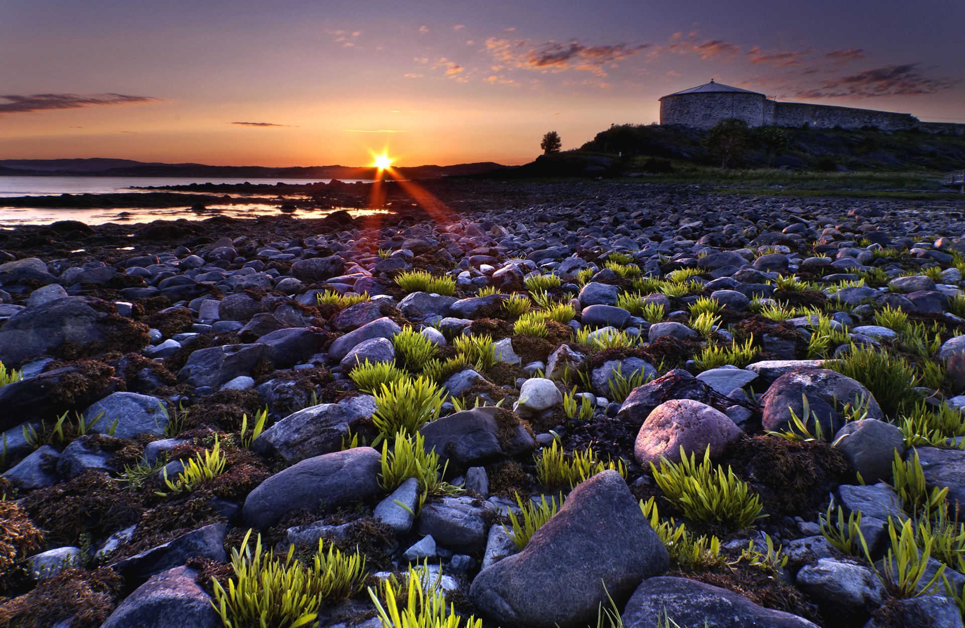 Sunset over rocky shore with fortress HD Wallpaper