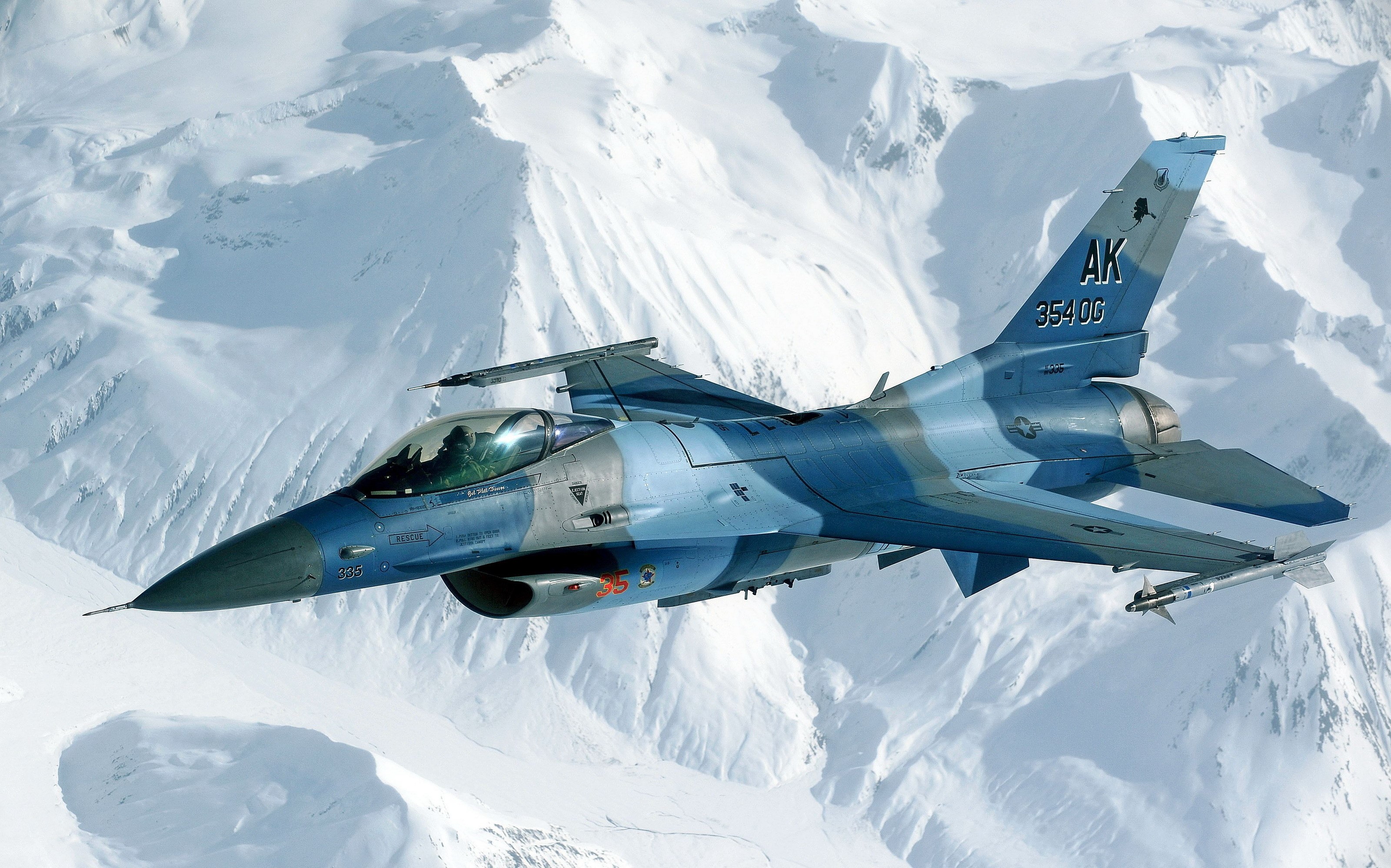 F-16 Fighting Falcon in flight over snowy mountains HD Wallpaper
