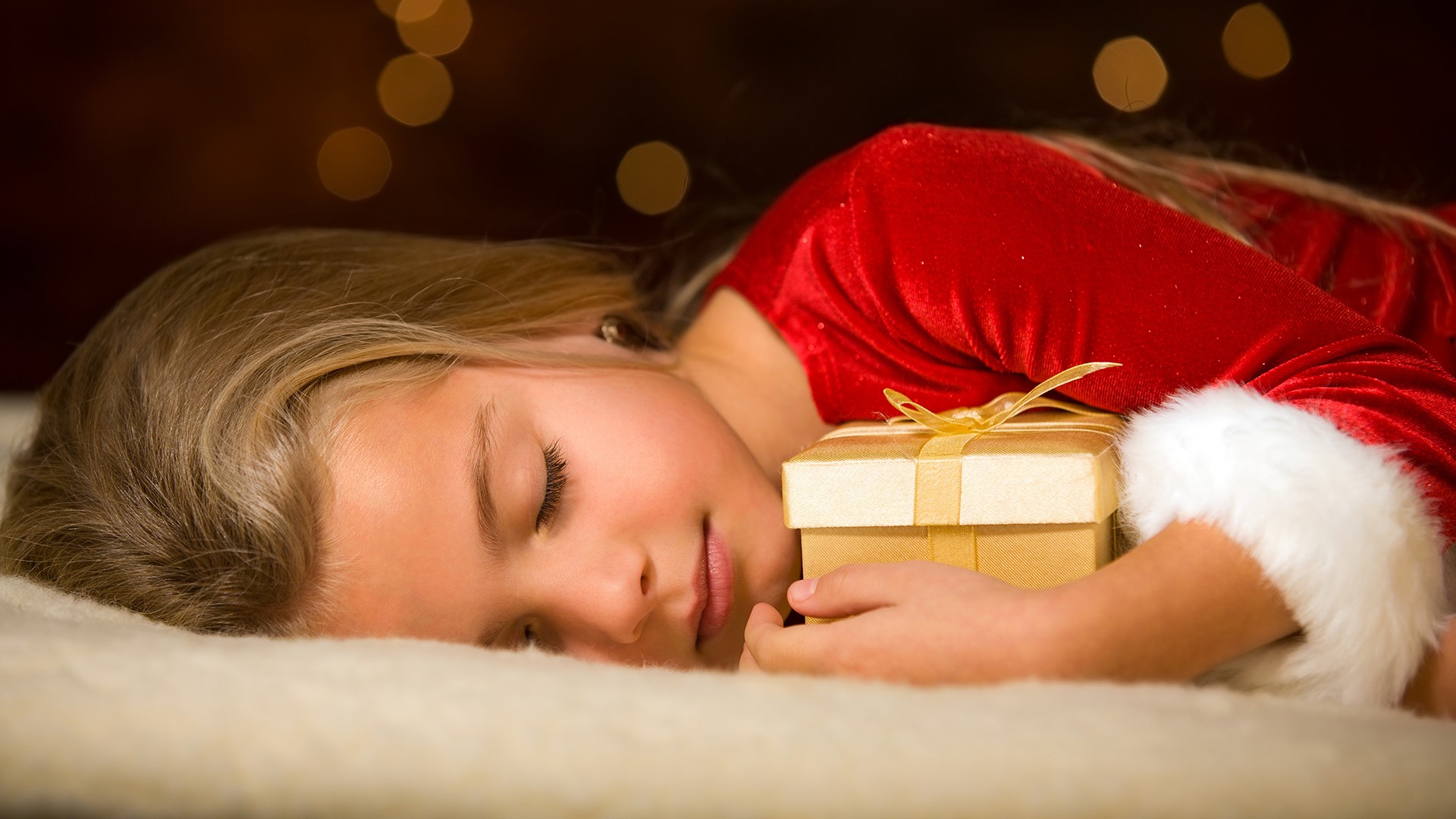Girl in Santa costume sleeping with gift HD Wallpaper