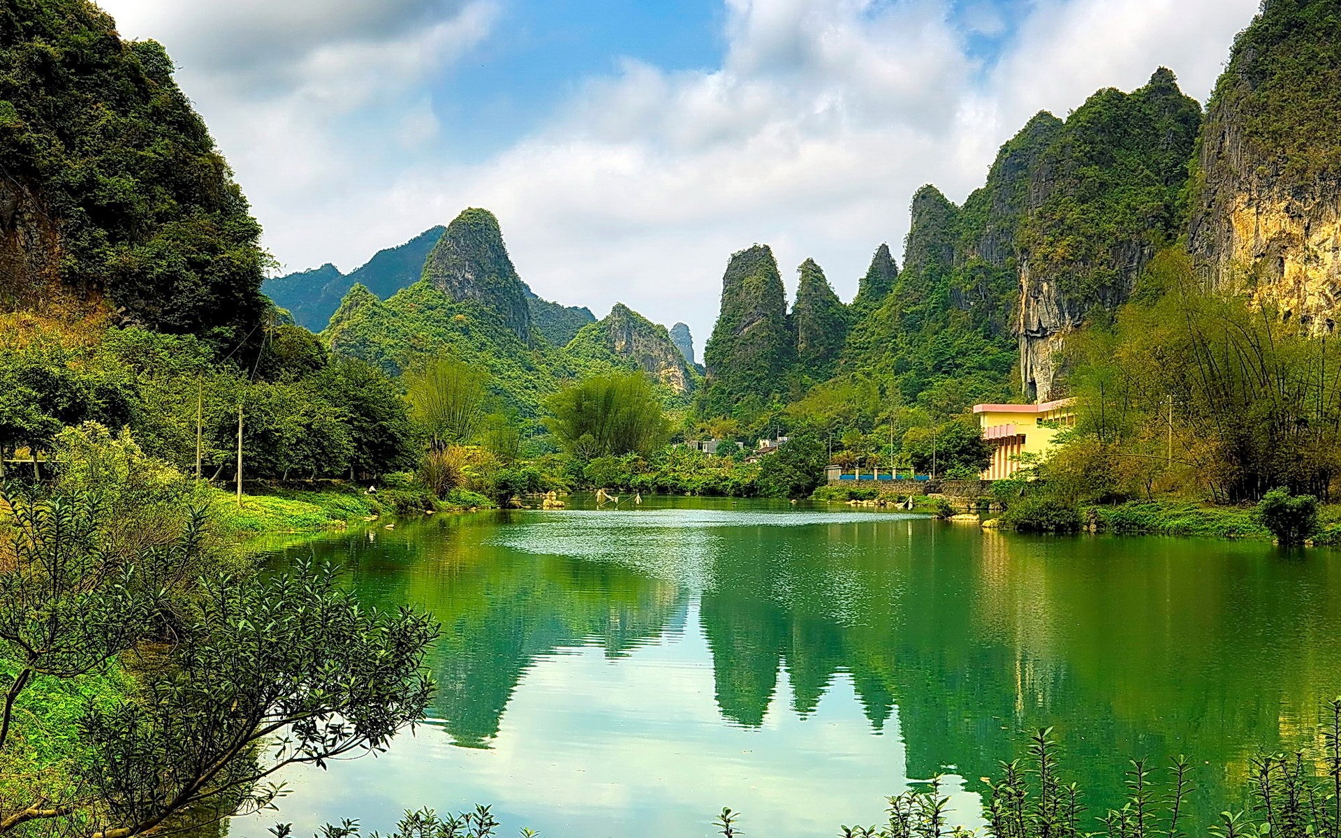 Karst mountains reflected in a green lake HD Wallpaper