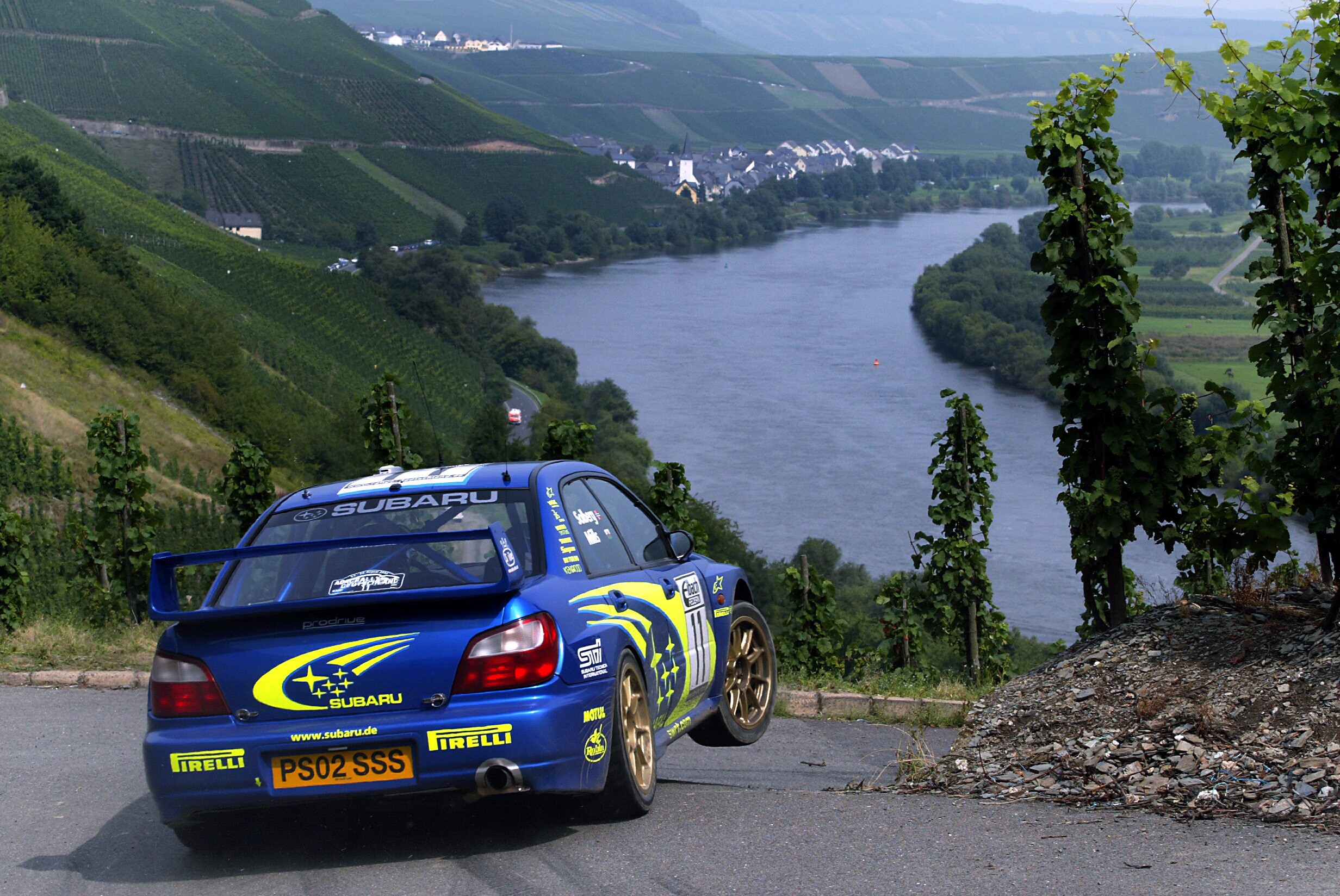 Blue Subaru rally car on a winding road HD Wallpaper