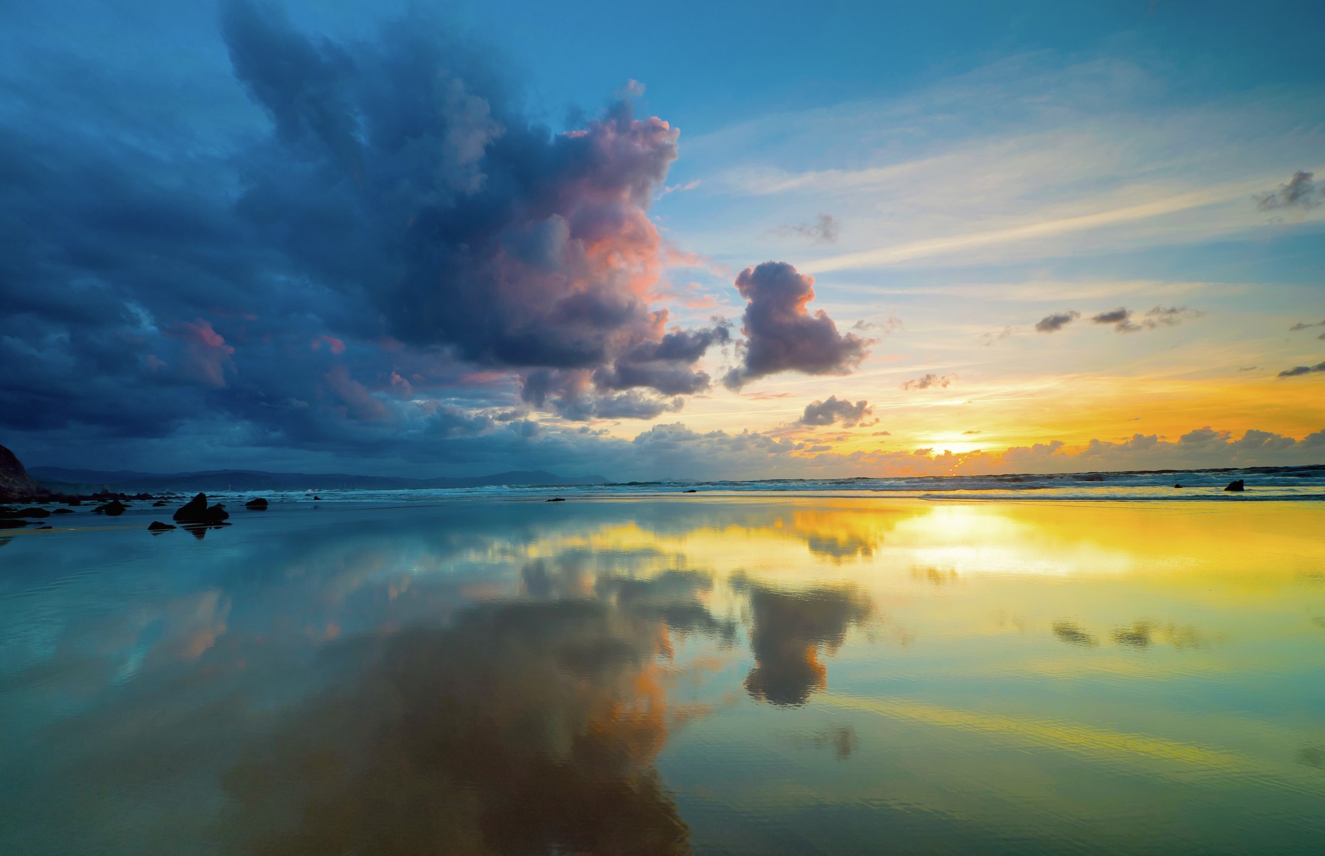 Sunset over a reflective beach with dramatic clouds HD Wallpaper