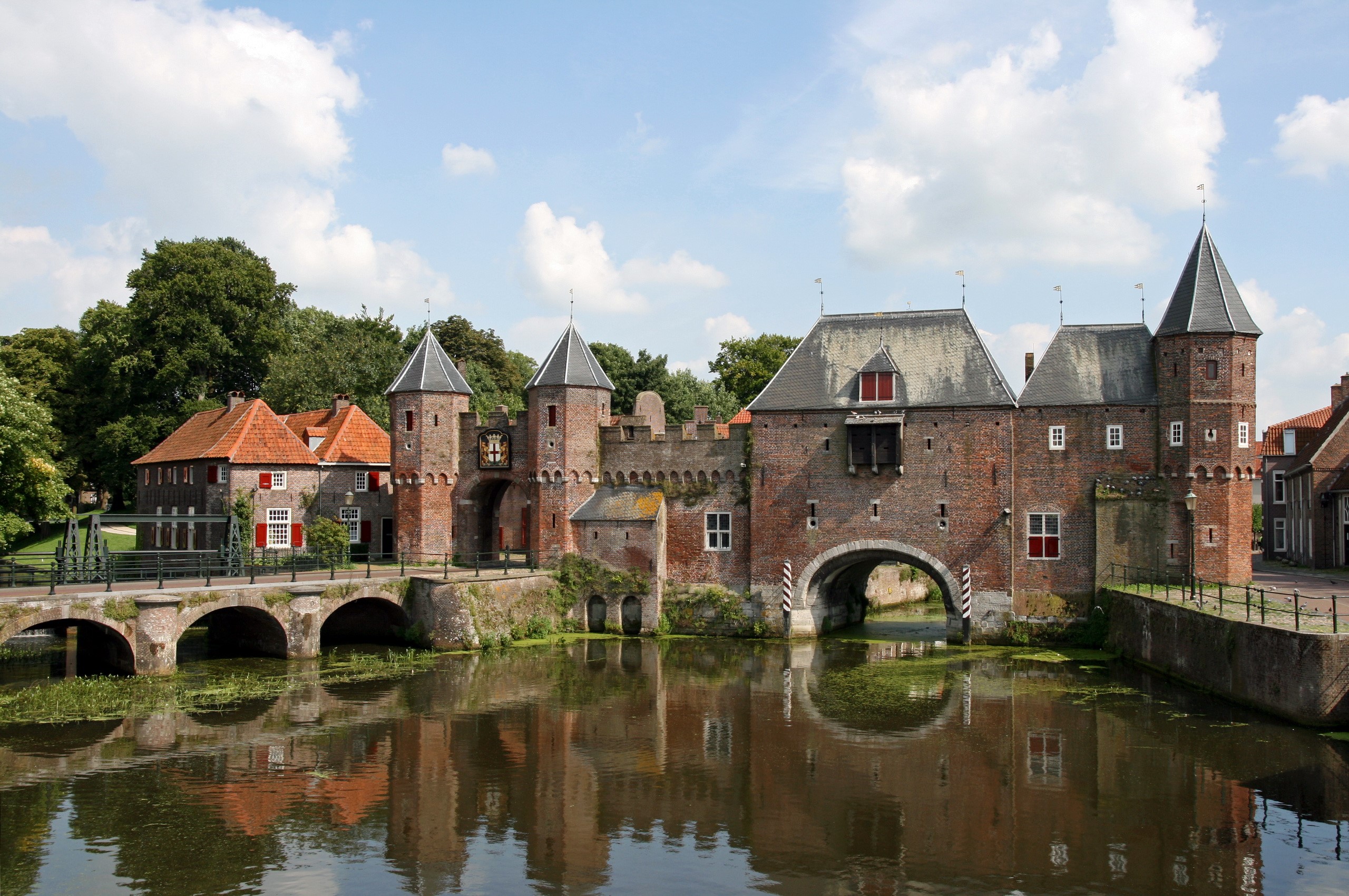 Historic brick gatehouse and bridge over water in Netherlands HD Wallpaper