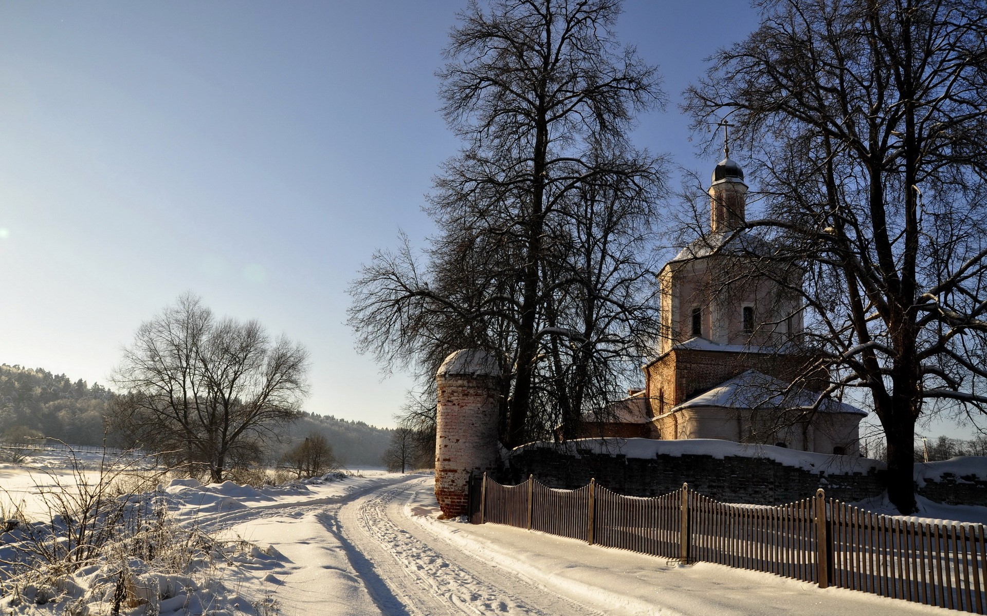 Winter road leading to a church with a stone fence HD Wallpaper