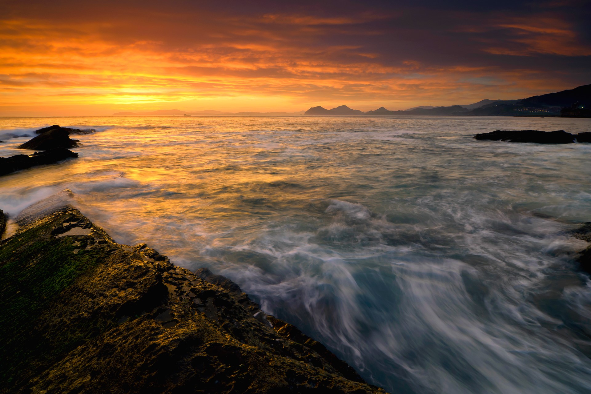 Ocean waves crashing on rocks at sunset HD Wallpaper