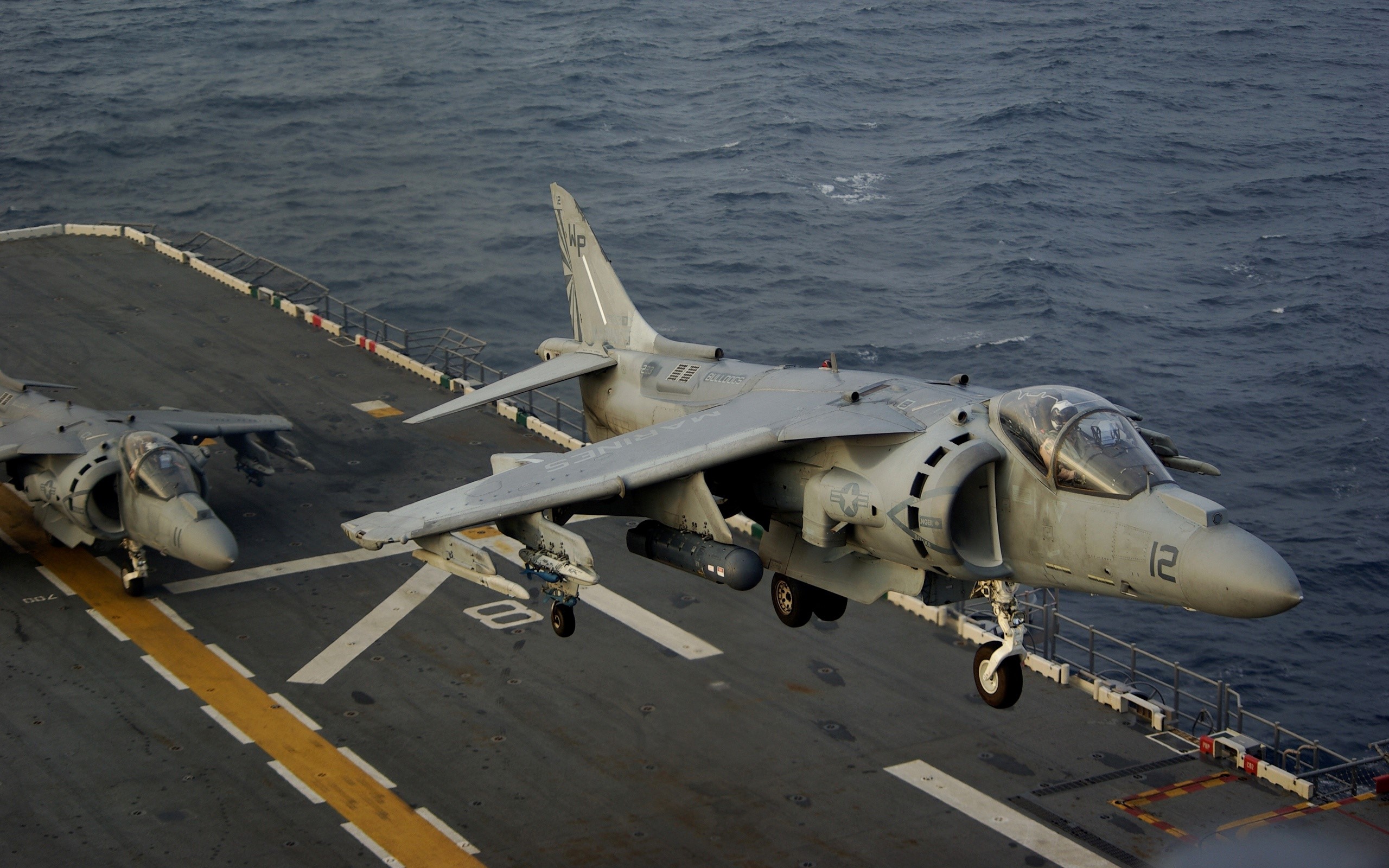 Two AV-8B Harrier II fighter jets on an aircraft carrier HD Wallpaper