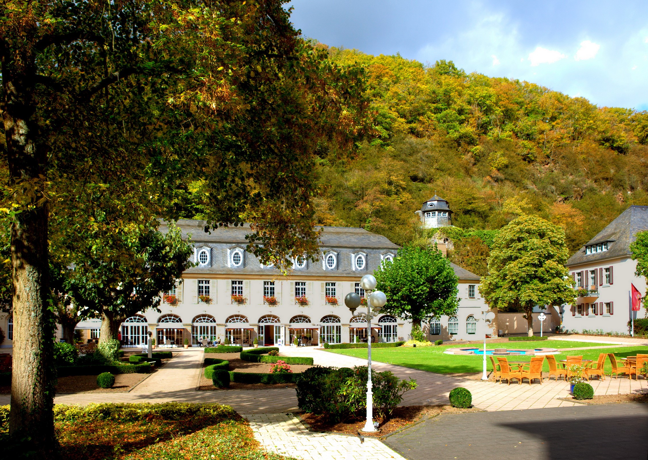 Hotel building with autumn trees and a tower on a hill HD Wallpaper