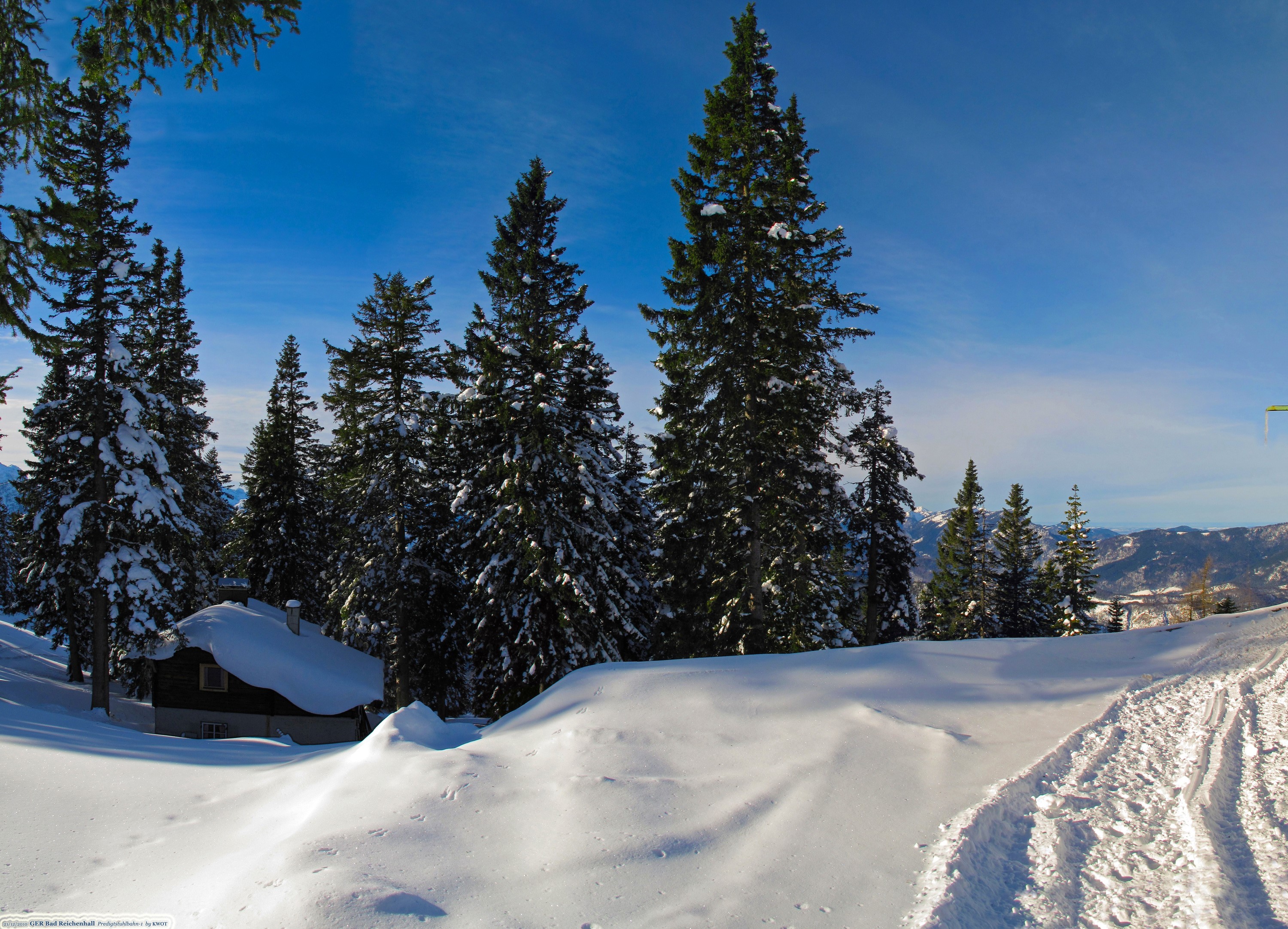 Snowy cabin and pine trees under a blue sky HD Wallpaper
