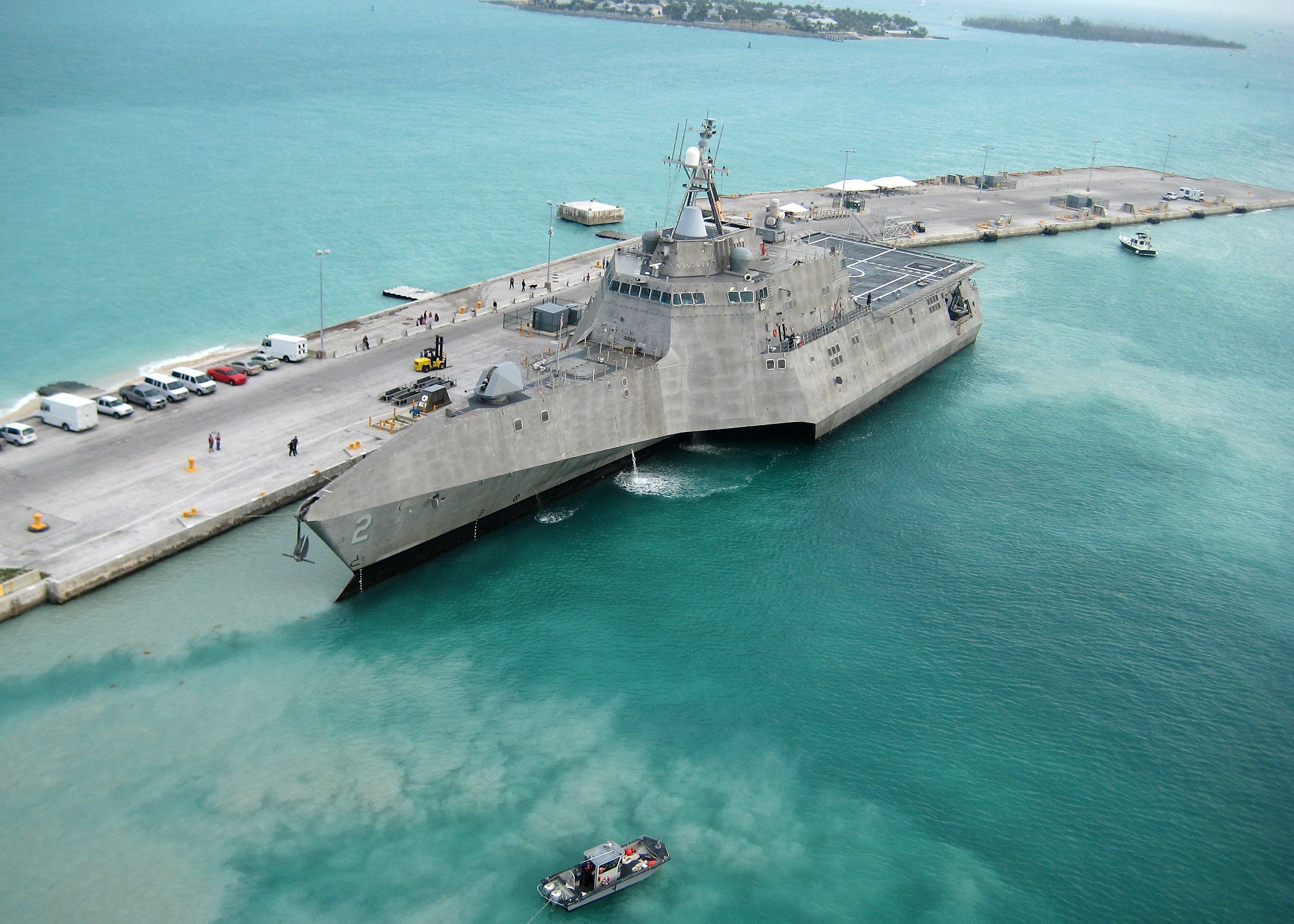 Naval Ship Docked at Pier with Small Boat HD Wallpaper