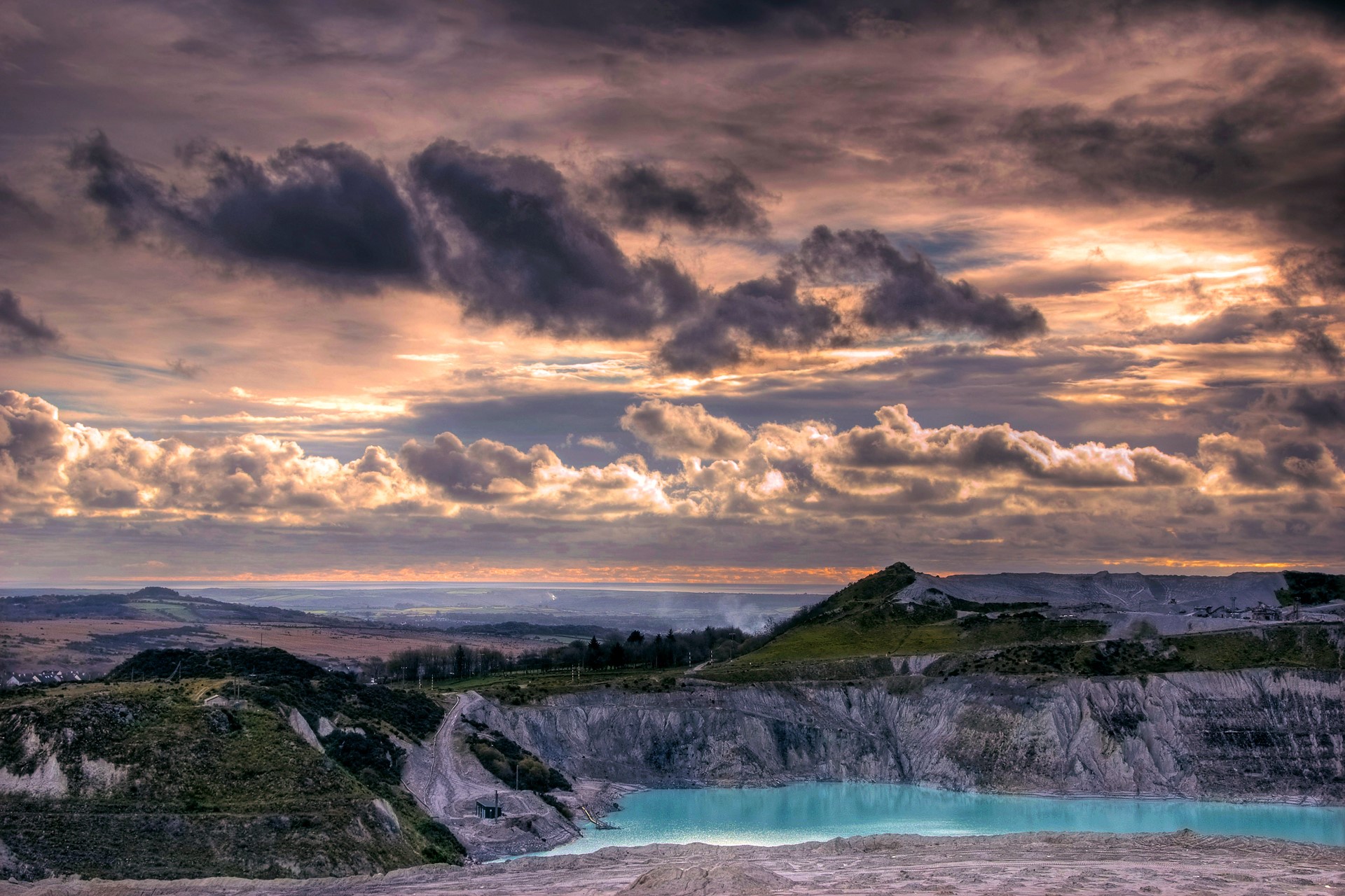 Dramatic sunset over a quarry with turquoise water HD Wallpaper