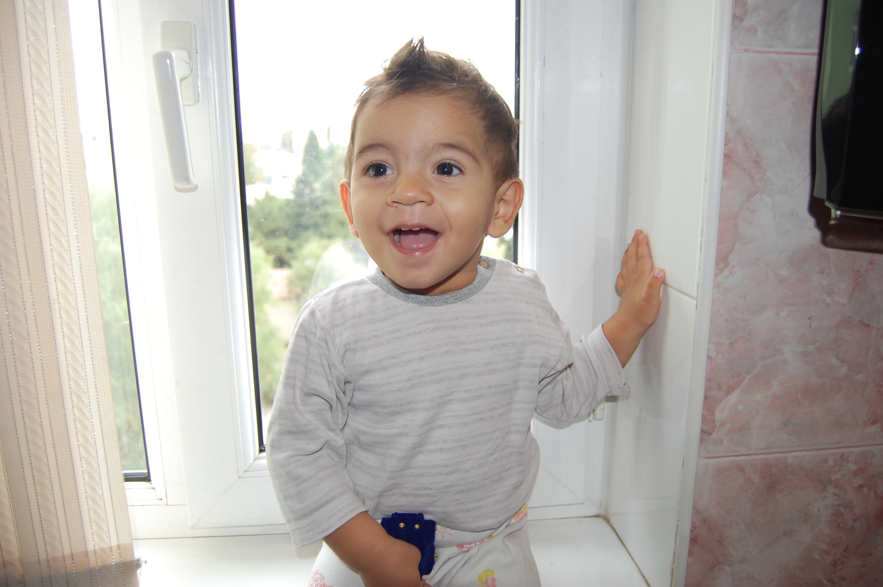 A smiling boy by the window HD Wallpaper