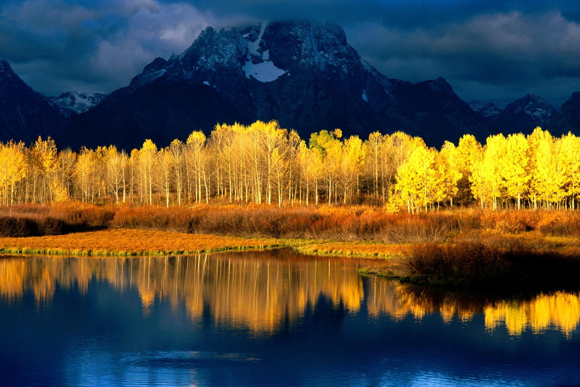 Autumn trees reflected in a lake with mountains HD Wallpaper