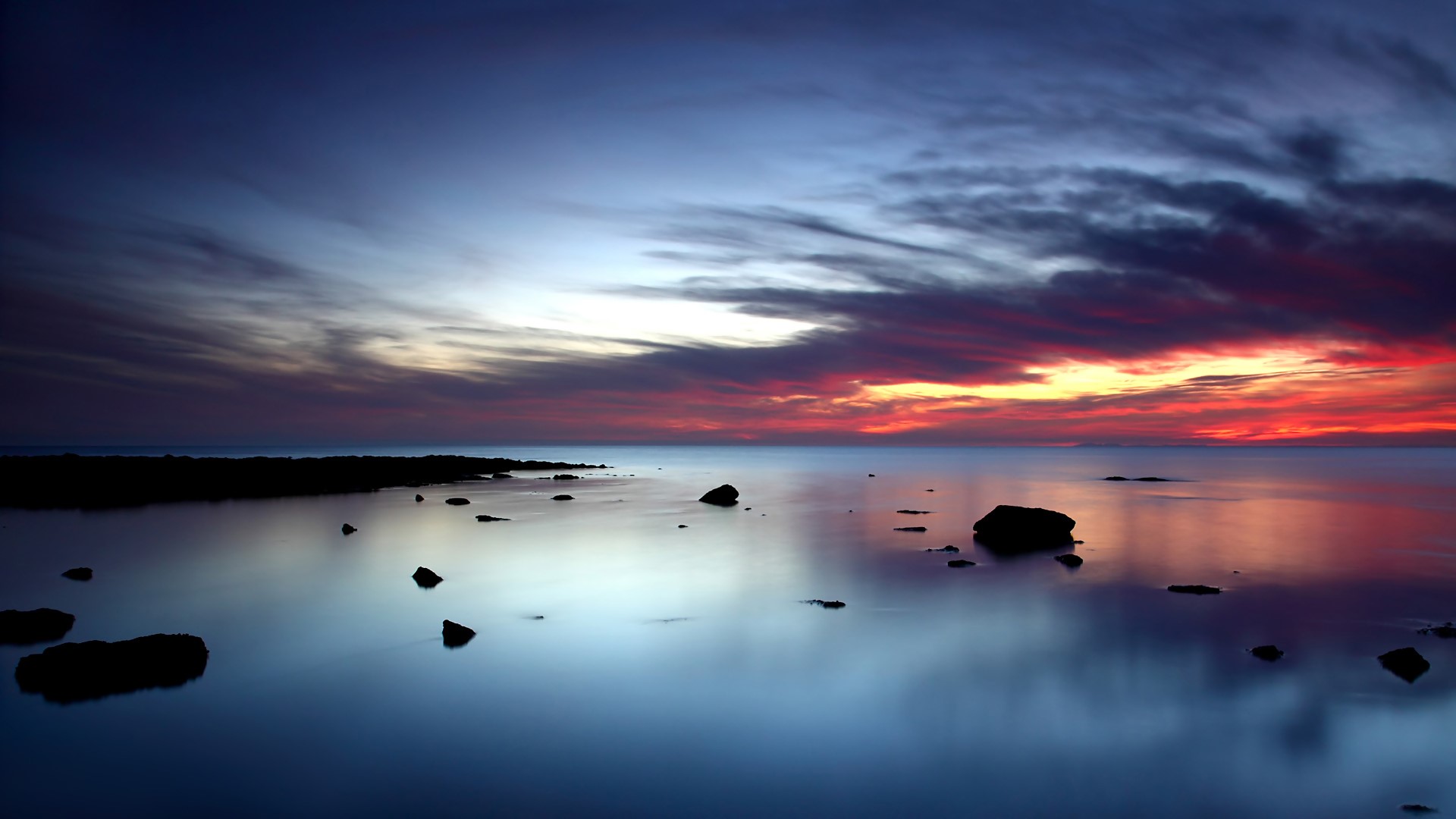 Sunset over the ocean with rocks HD Wallpaper