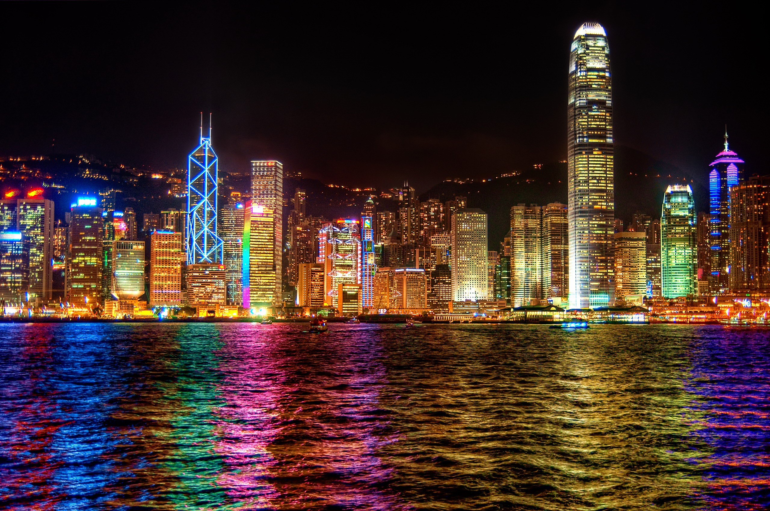 Hong Kong skyline at night with colorful reflections HD Wallpaper