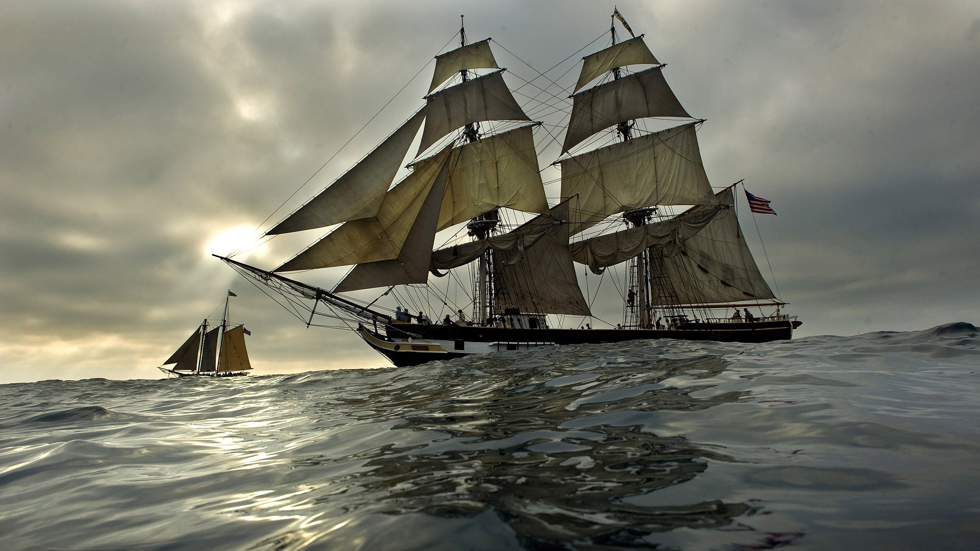 Two sailing ships on the ocean under a cloudy sky HD Wallpaper