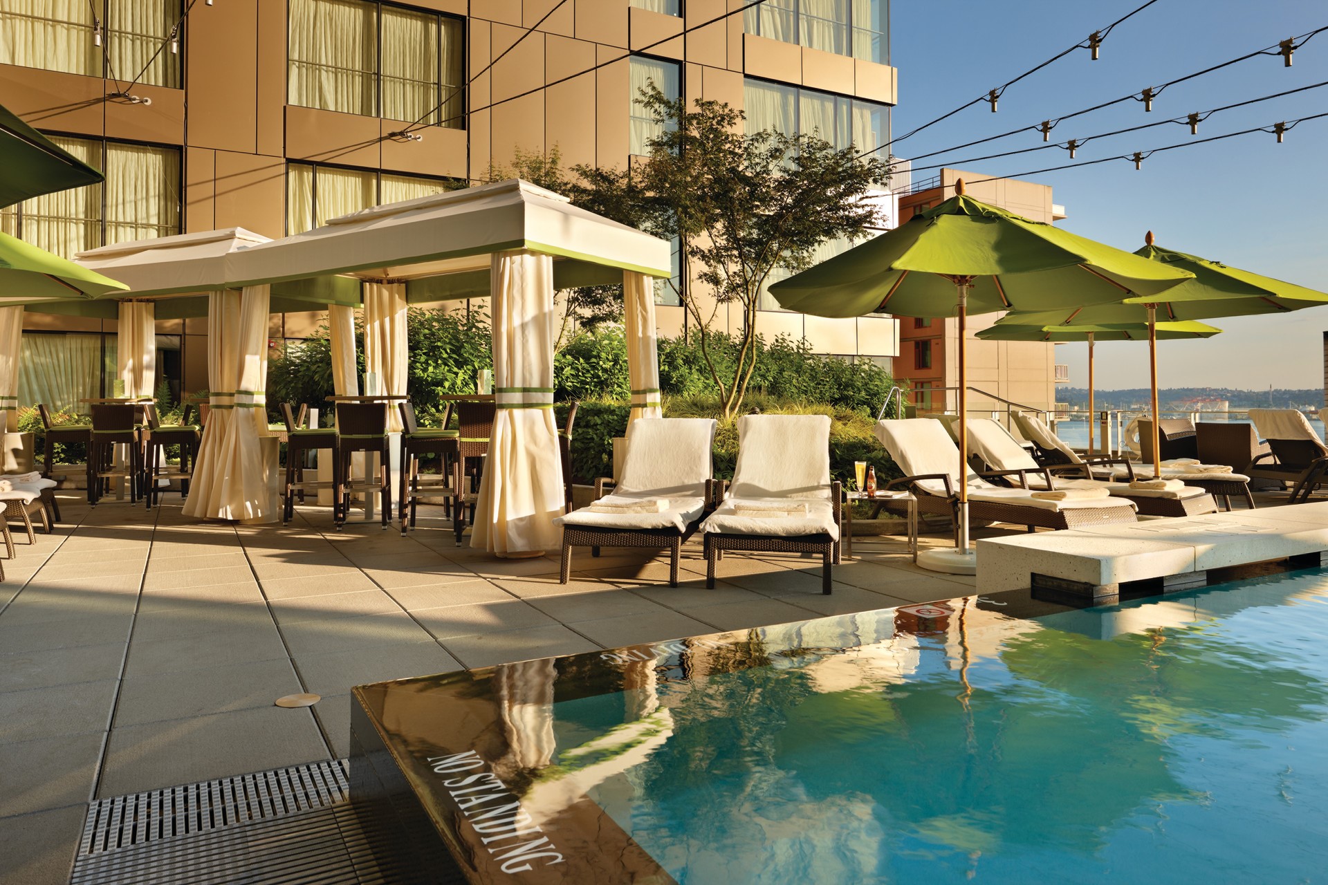 Resort pool deck with cabanas and lounge chairs HD Wallpaper