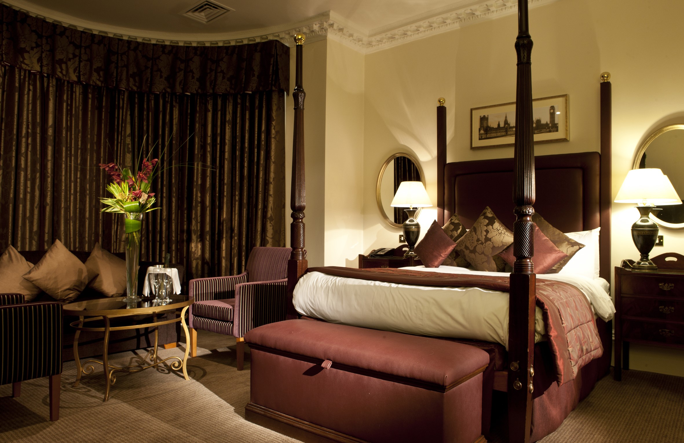 Luxurious hotel room with four-poster bed and seating area HD Wallpaper