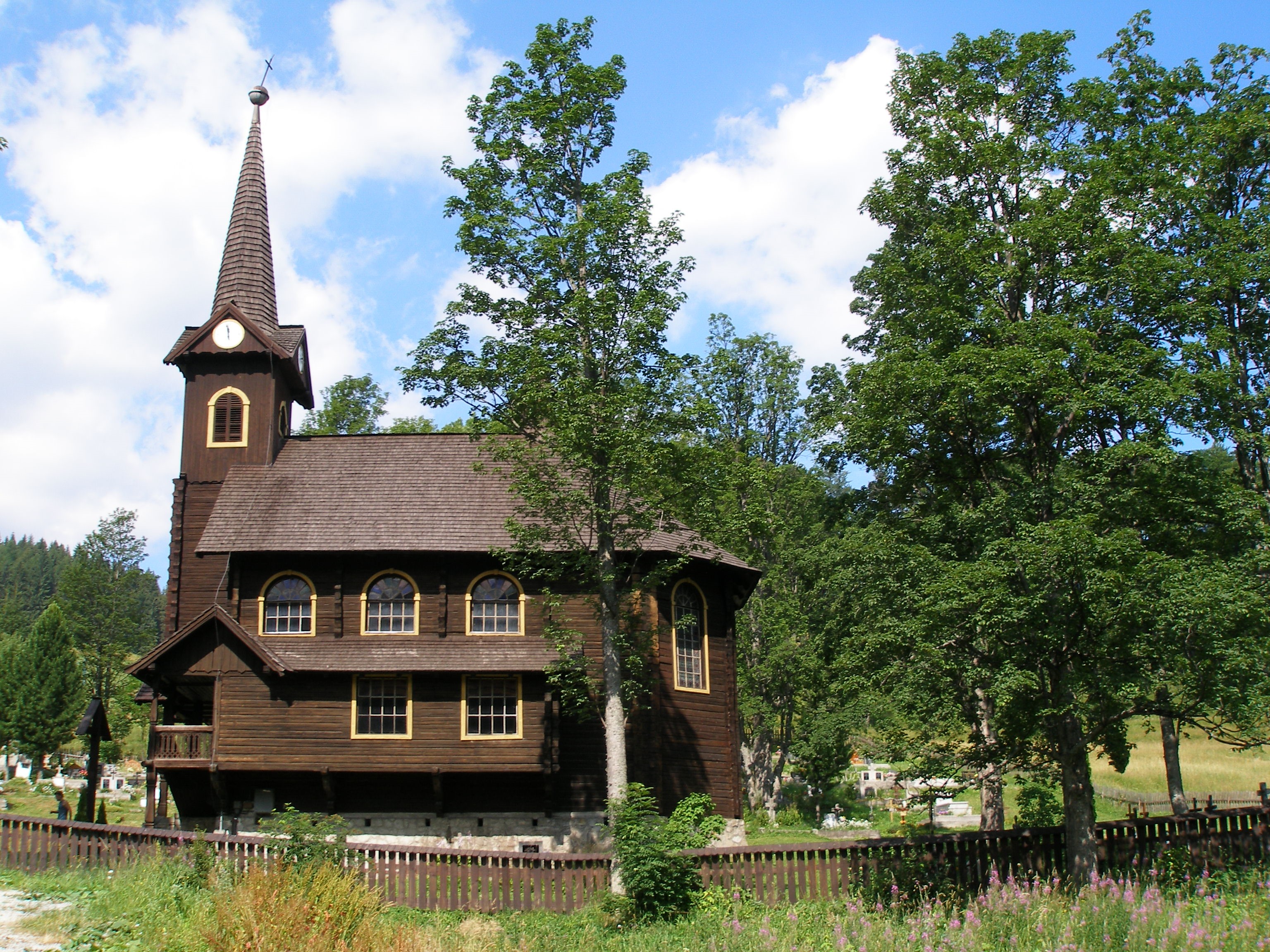 Wooden church with a steeple and clock tower HD Wallpaper