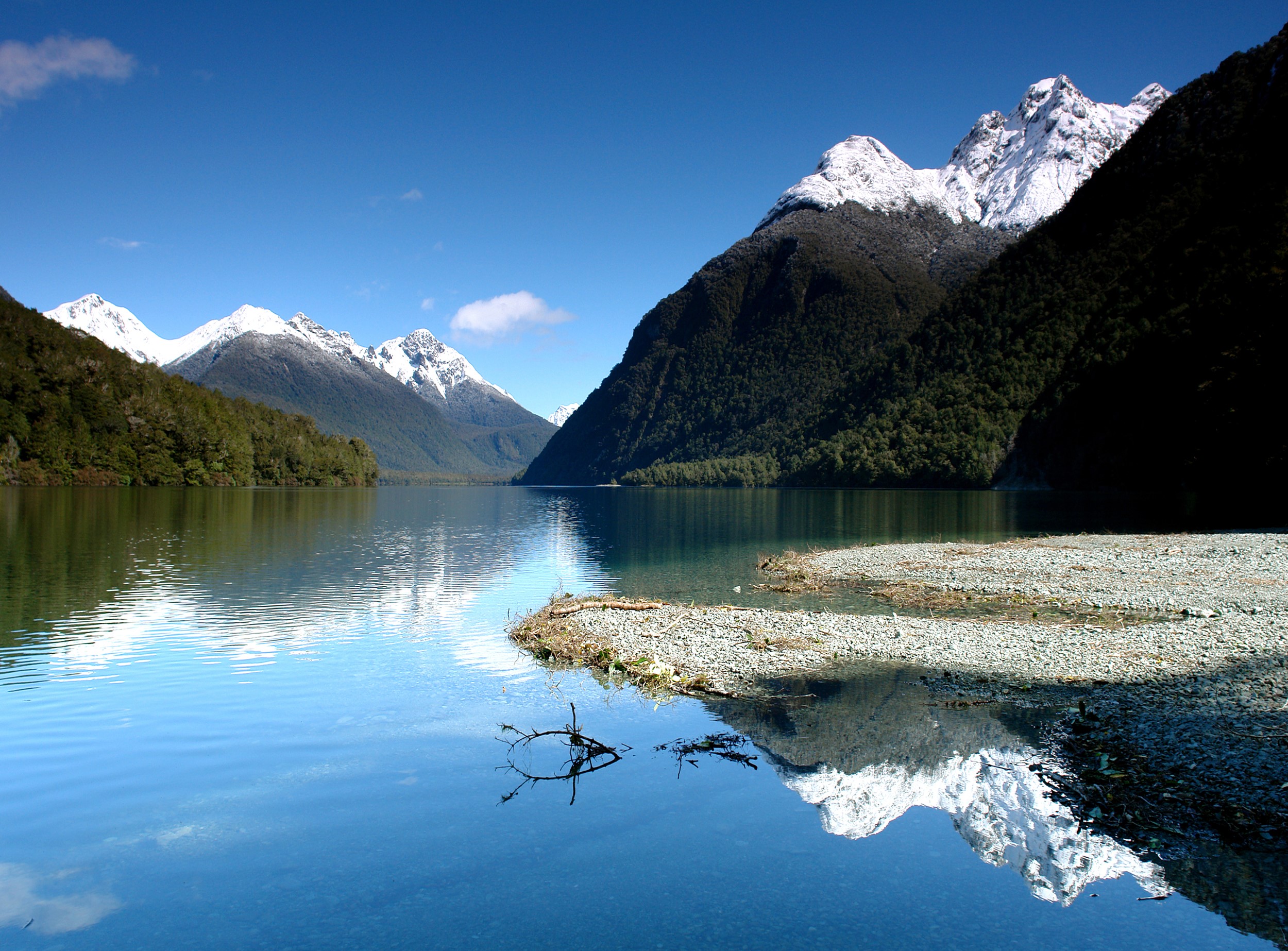 Snow-capped mountains reflected in a clear lake HD Wallpaper