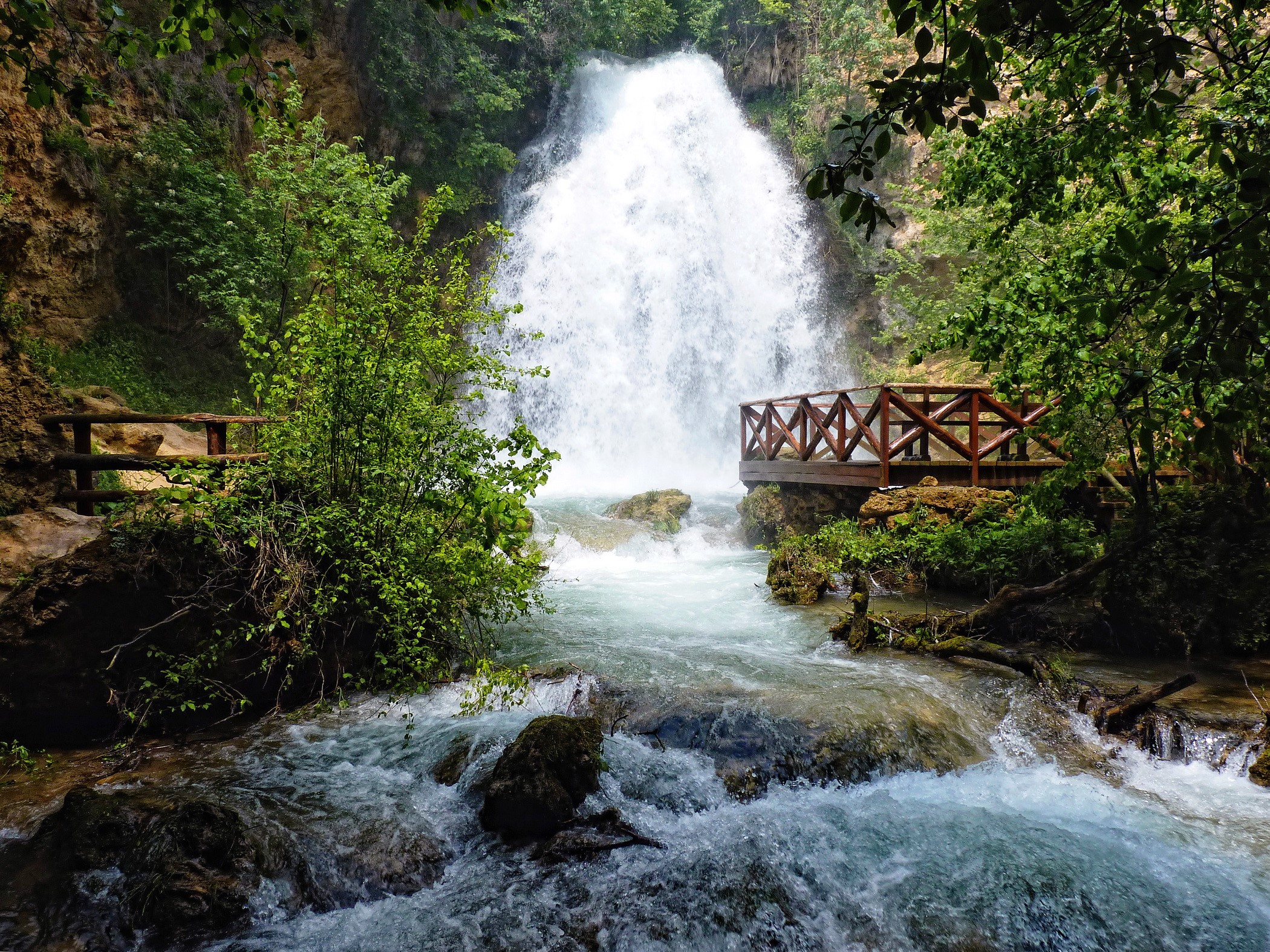 Waterfall with wooden viewing platforms and lush greenery HD Wallpaper