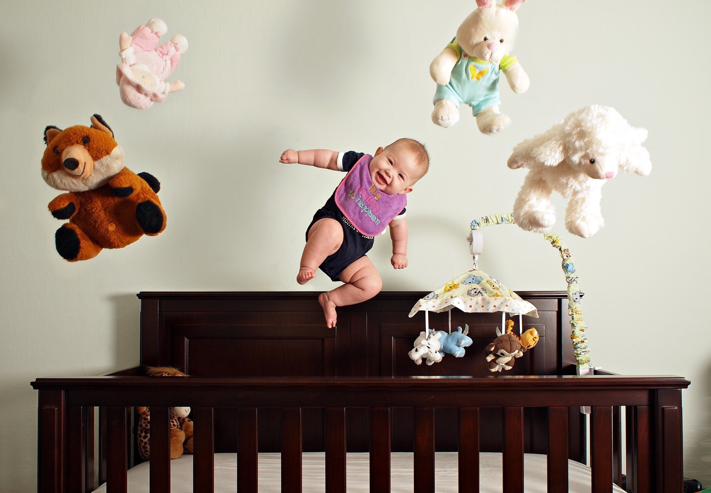 Baby jumping with toys in a nursery HD Wallpaper