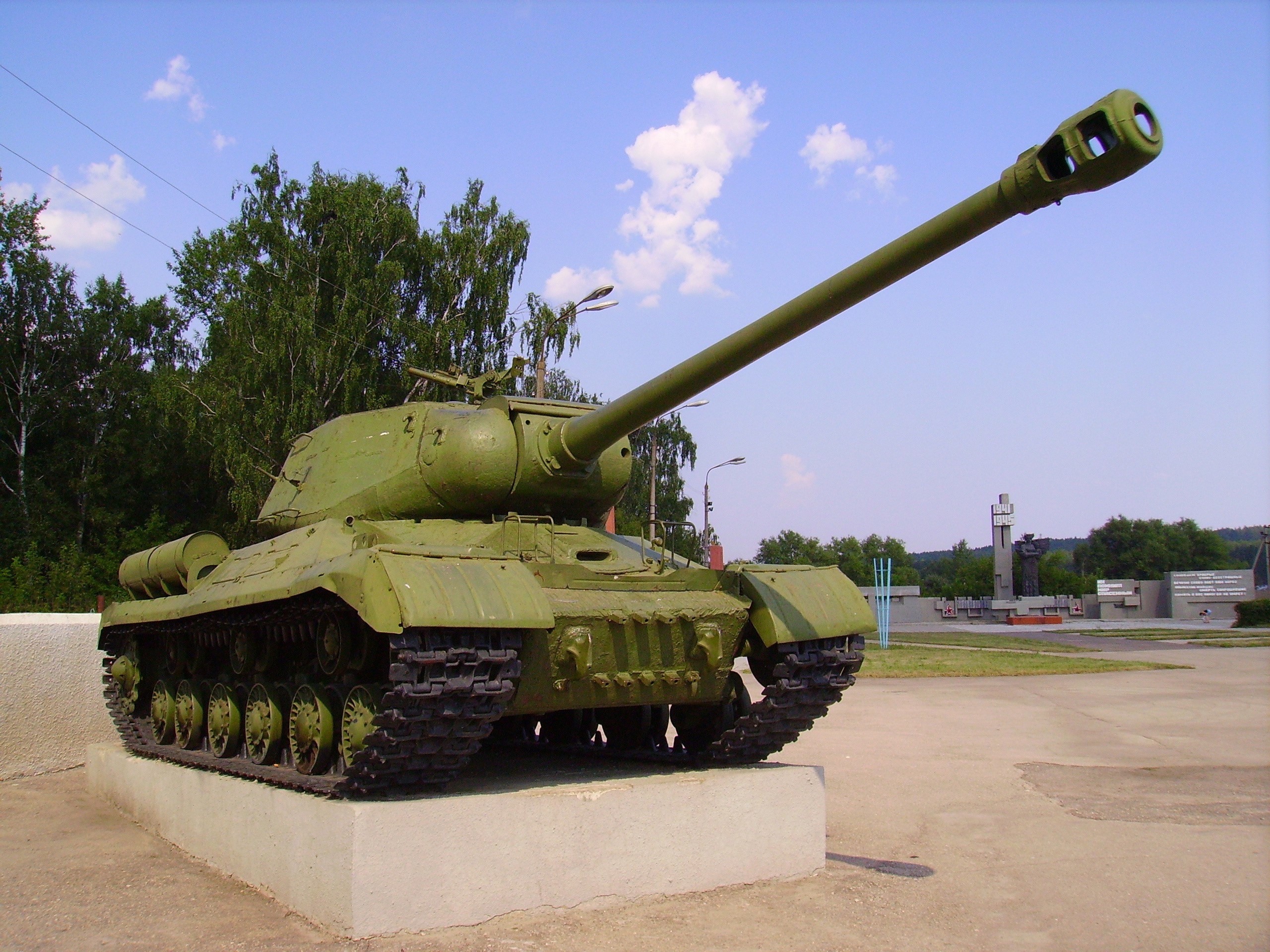 Green tank on a concrete pedestal outdoors HD Wallpaper