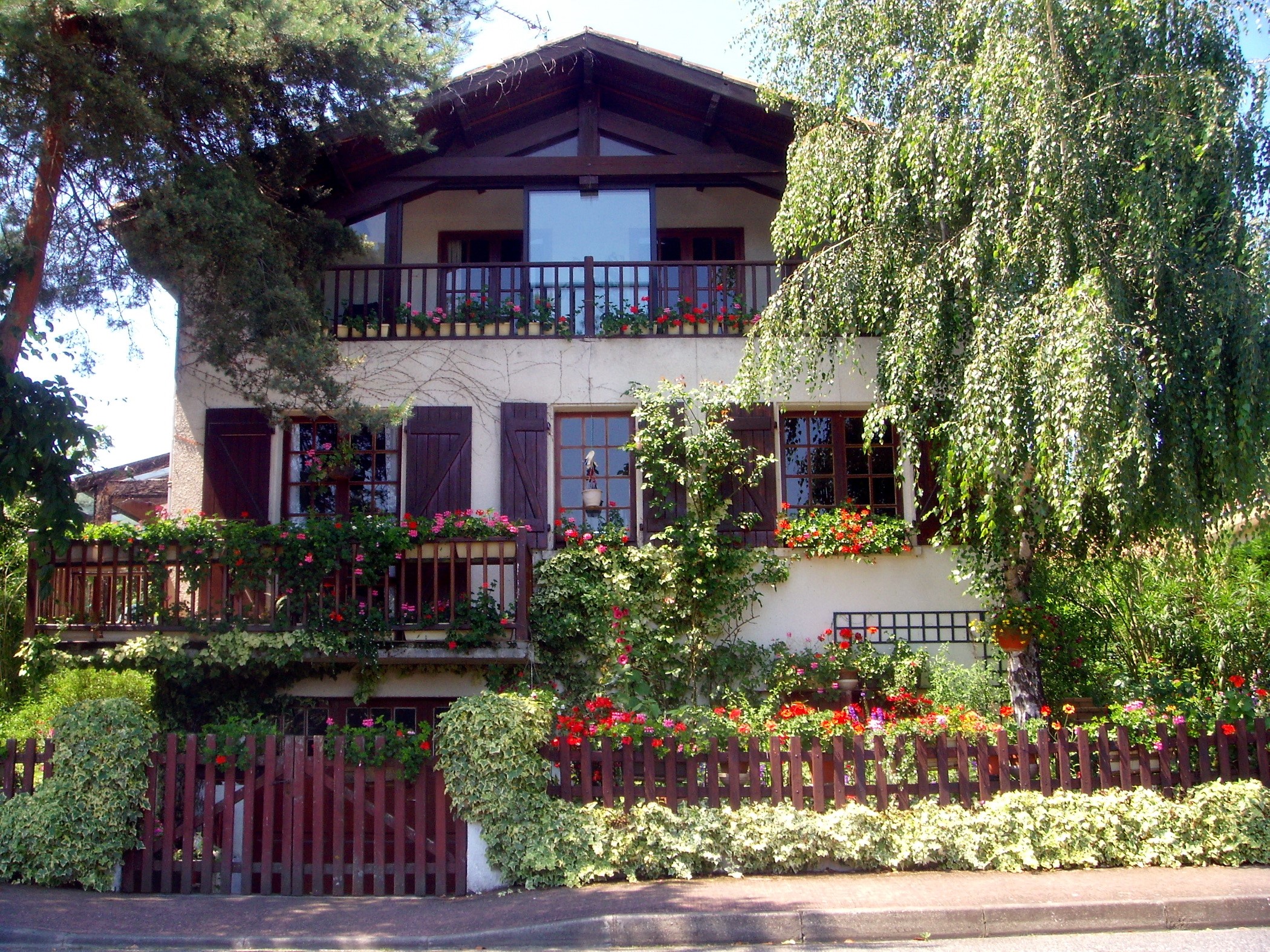 House with balconies and flowers in France HD Wallpaper