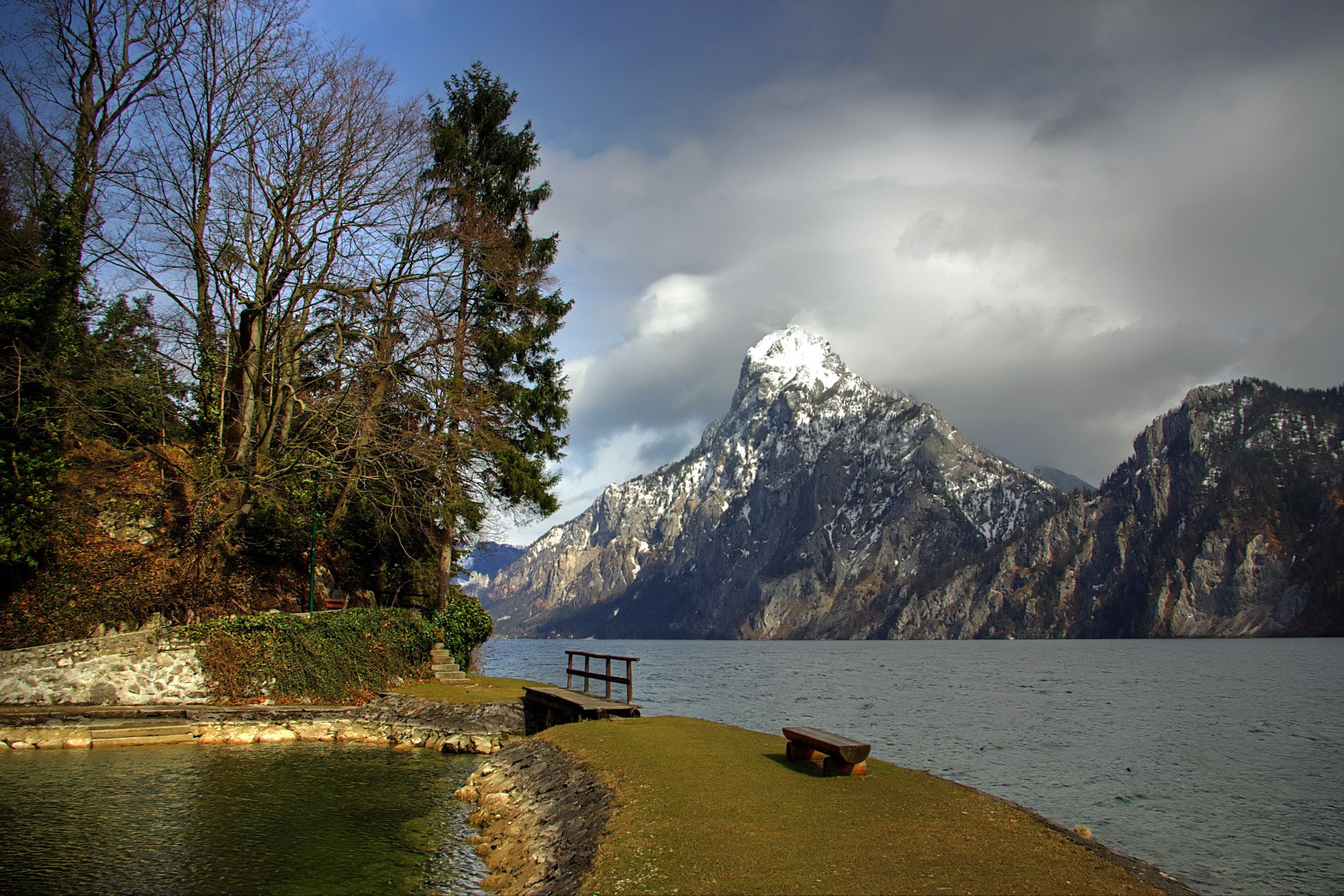 Lake and snow-capped mountain with trees and bench HD Wallpaper