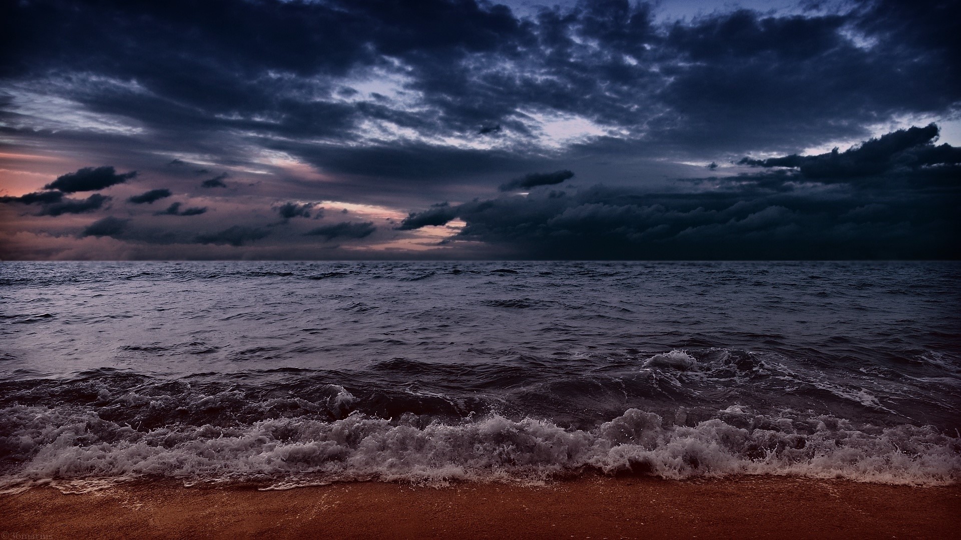 Dark stormy clouds over the ocean and beach HD Wallpaper