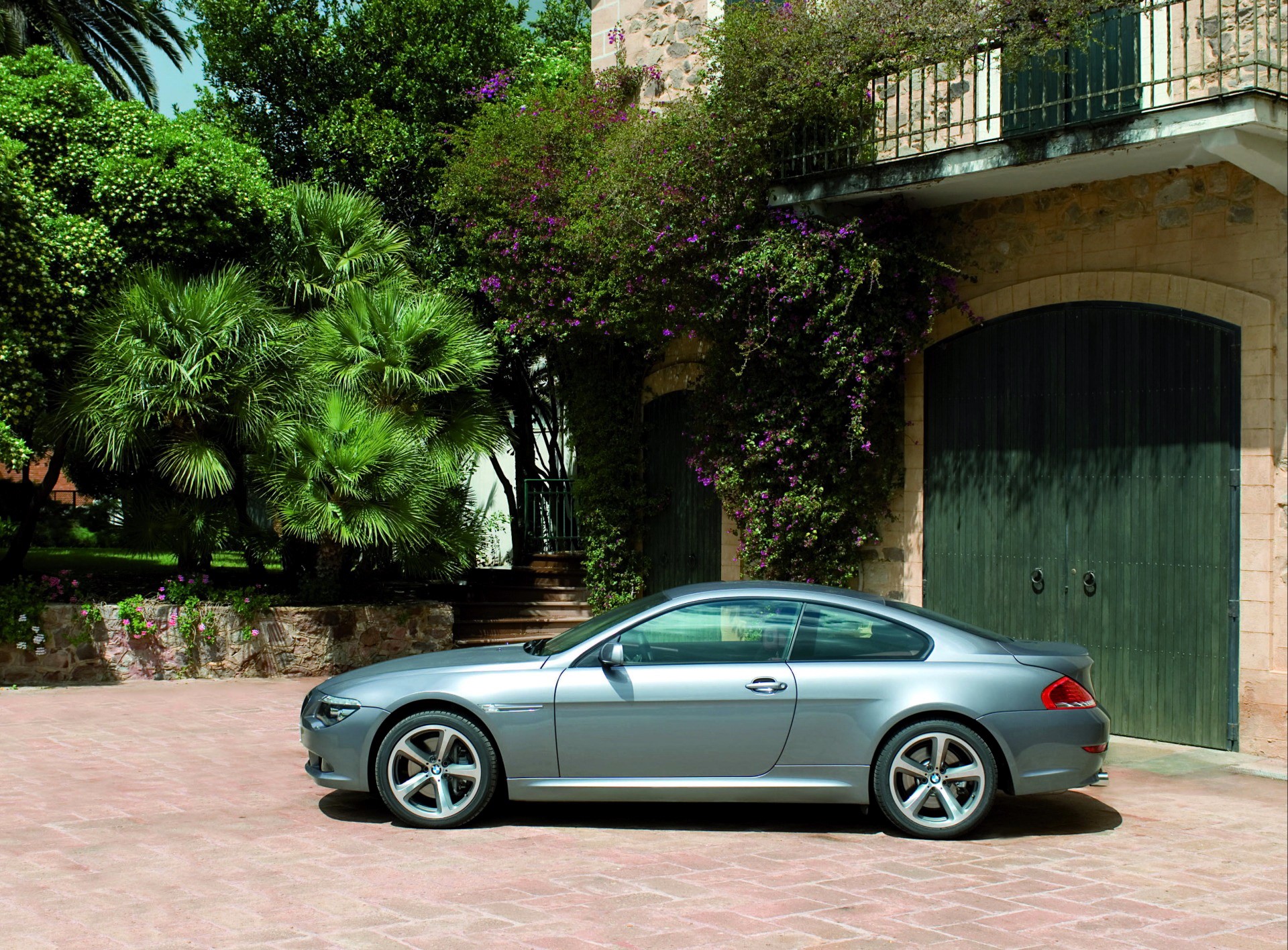 Silver BMW coupe parked in front of a stone building with green doors HD Wallpaper