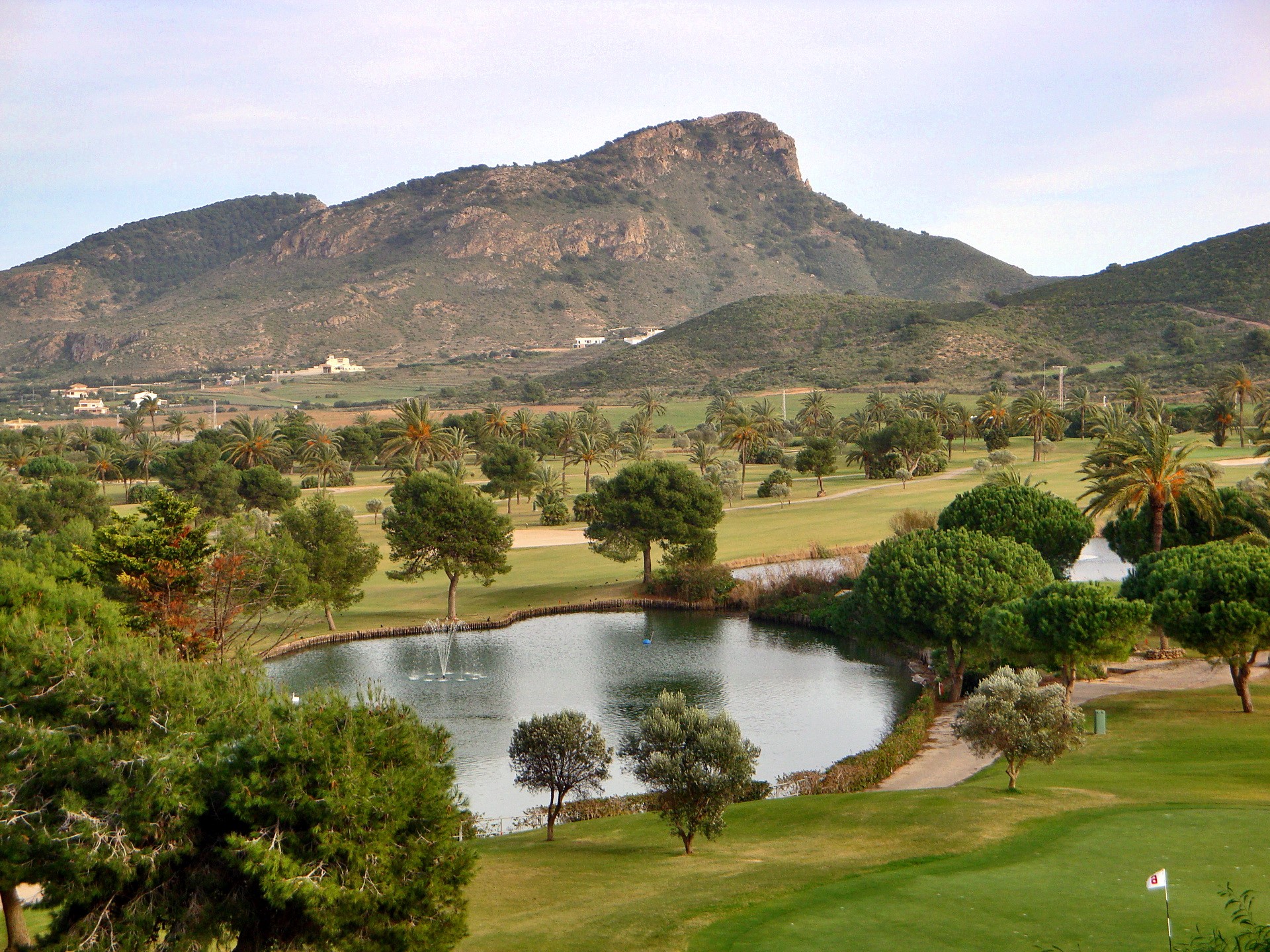Golf course with a pond and mountains HD Wallpaper